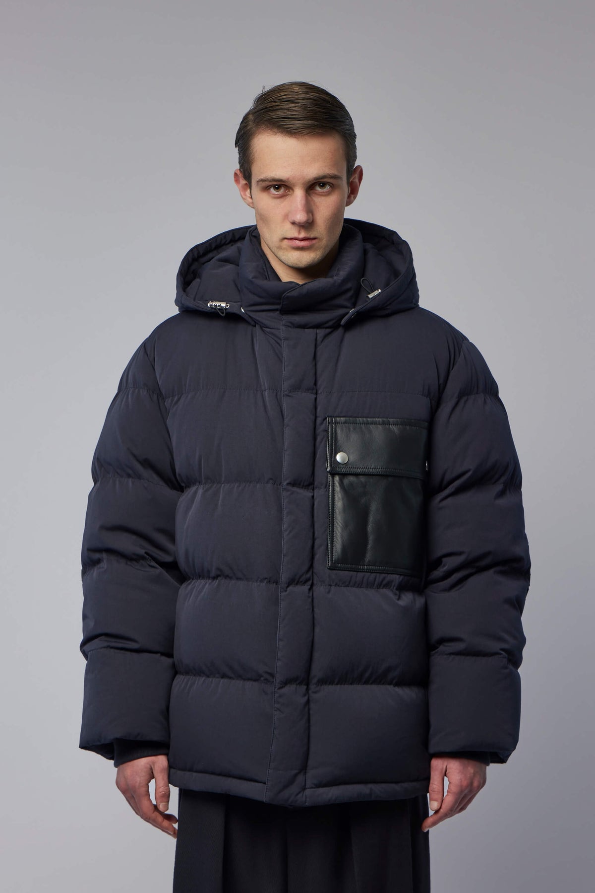 Close-up view of quilted construction and silver button details on luxury puffer jacket