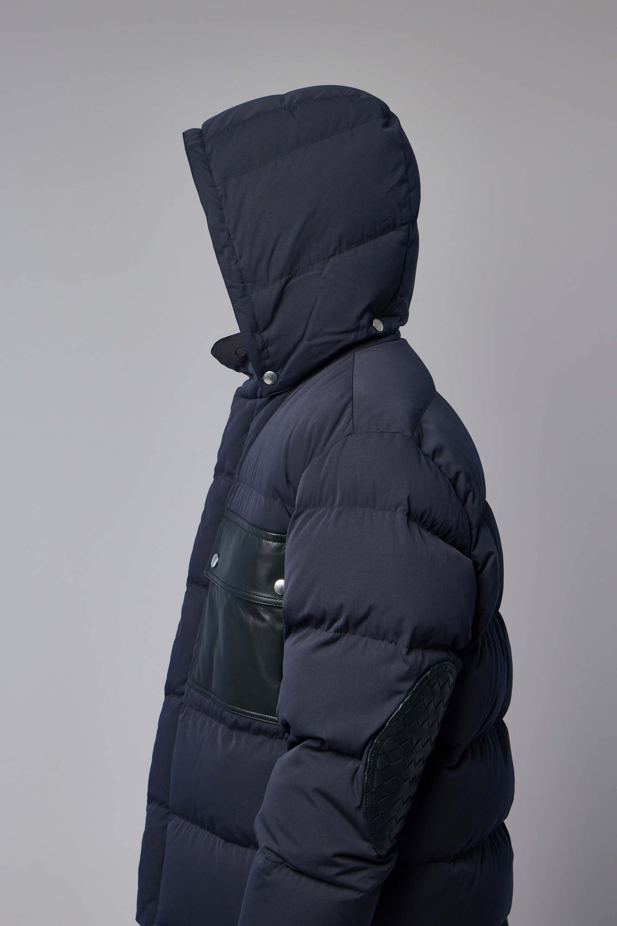 Front view highlighting large pocket and hooded design of premium outerwear