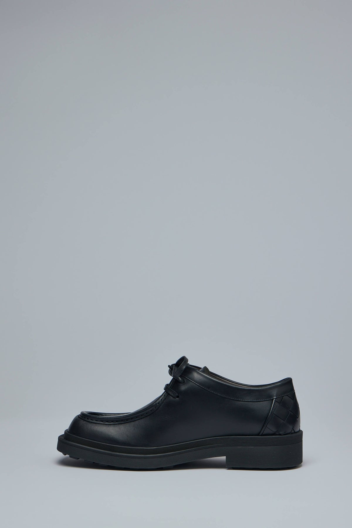 Side profile of black leather Bottega Veneta flats showing rounded toe shape