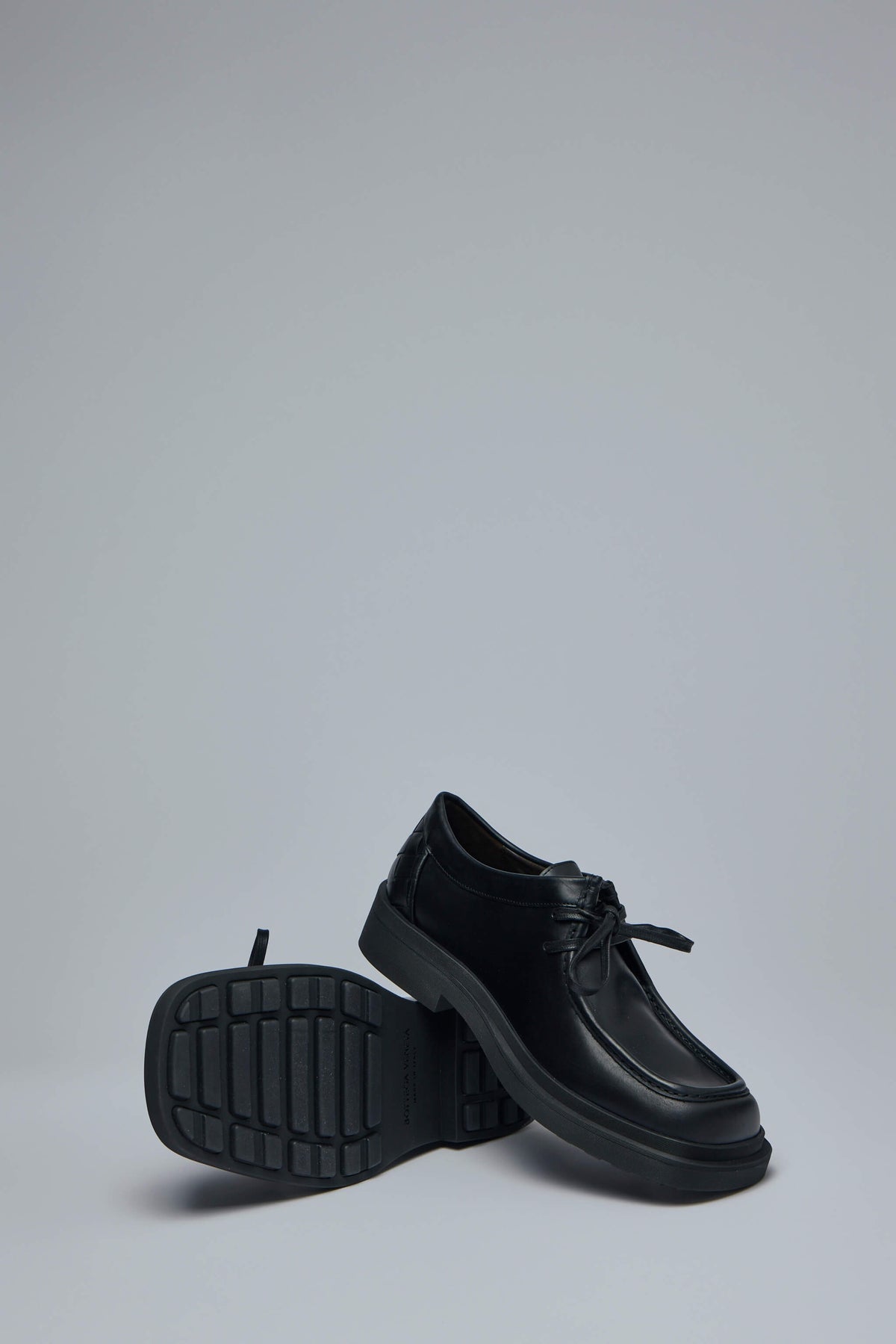 Full view of Bottega Veneta black leather flats with polished finish