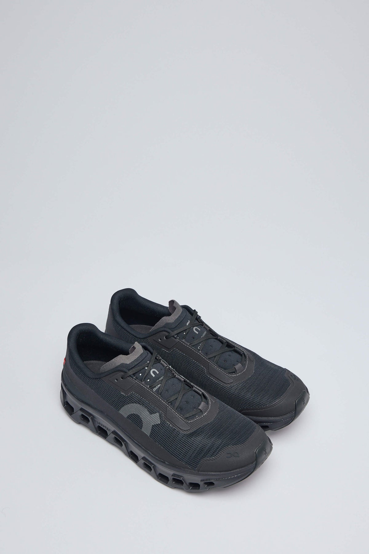Side view of ON Running Cloudmonster sneakers showing logo detail