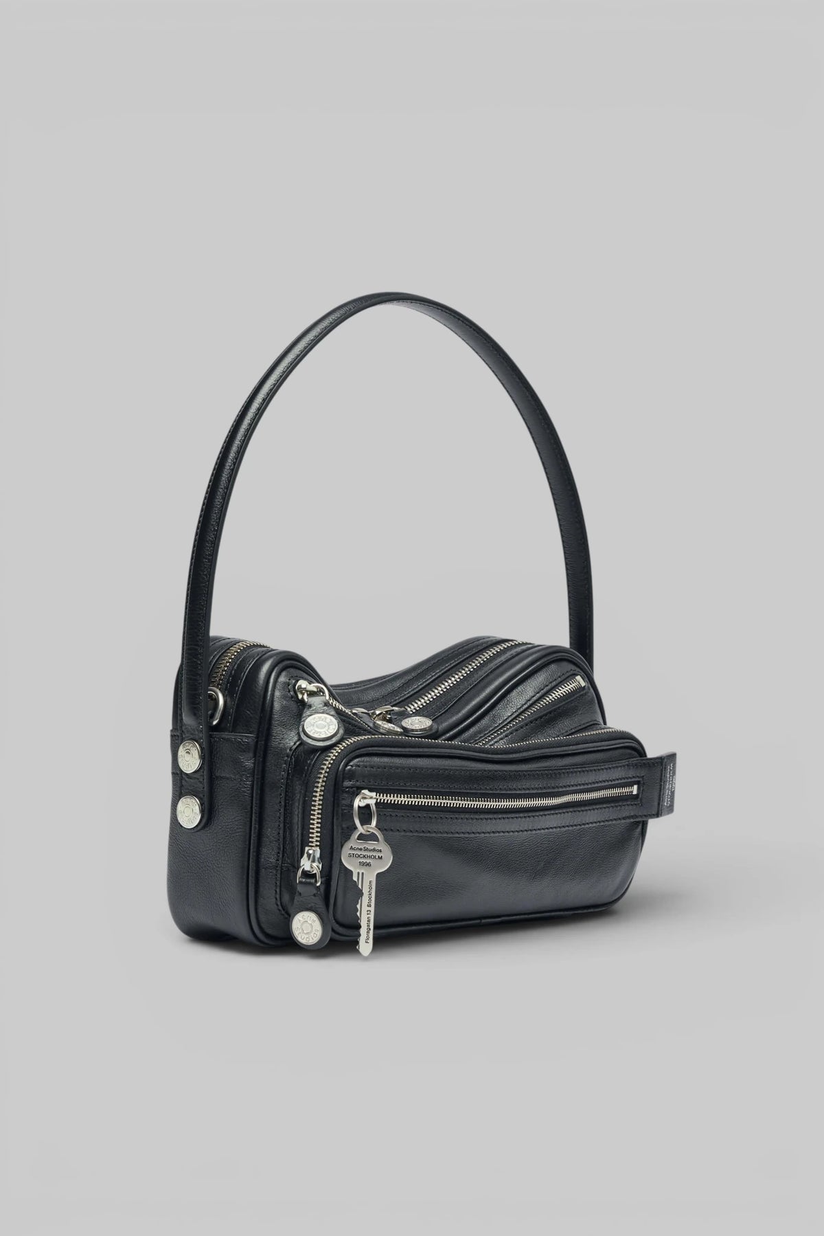 Close-up of metallic zipper hardware on Acne Studios shoulder bag