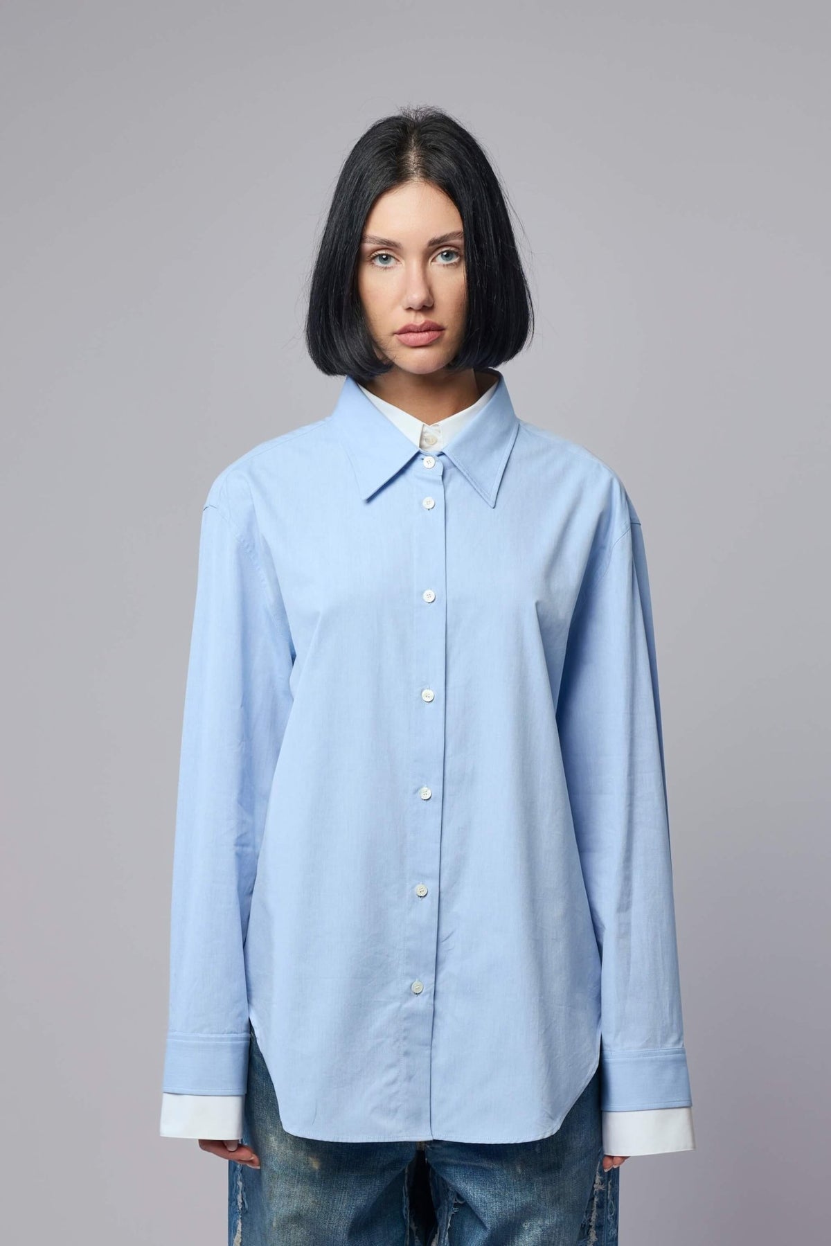 Light blue cotton button-up shirt with white buttons and relaxed fit