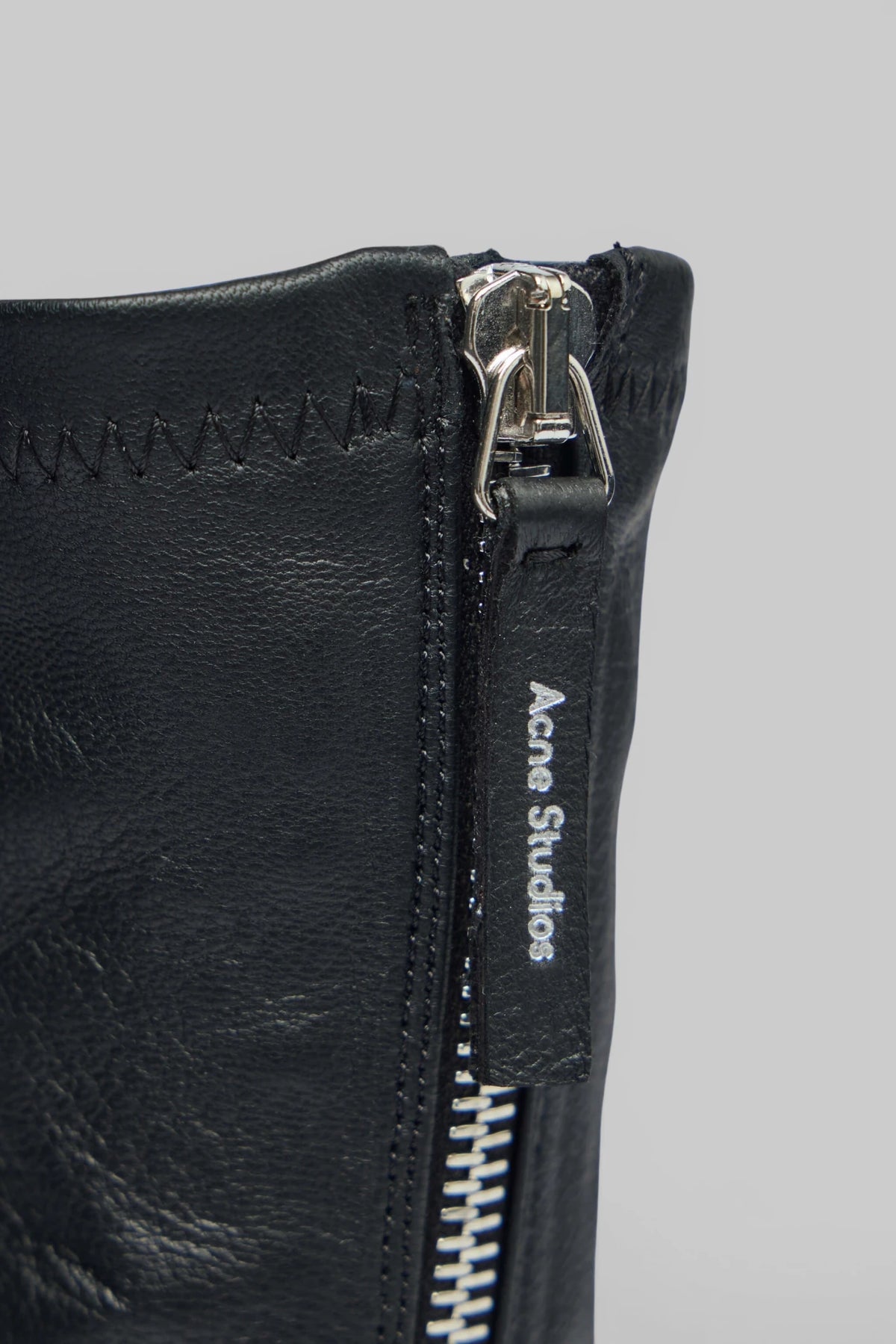 Full pair of Acne Studios leather ankle boots on white background