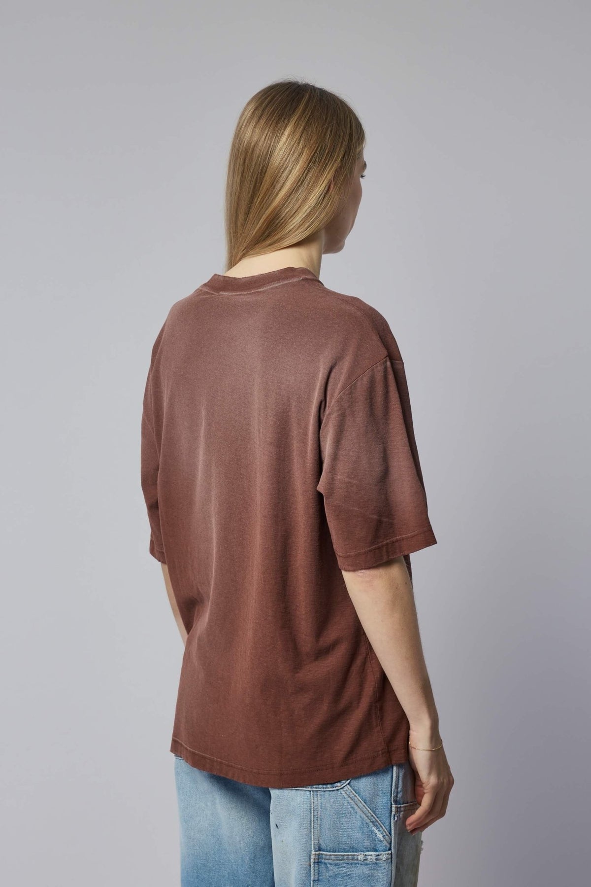 Flat lay of white Acne Studios logo pocket t-shirt on neutral background
