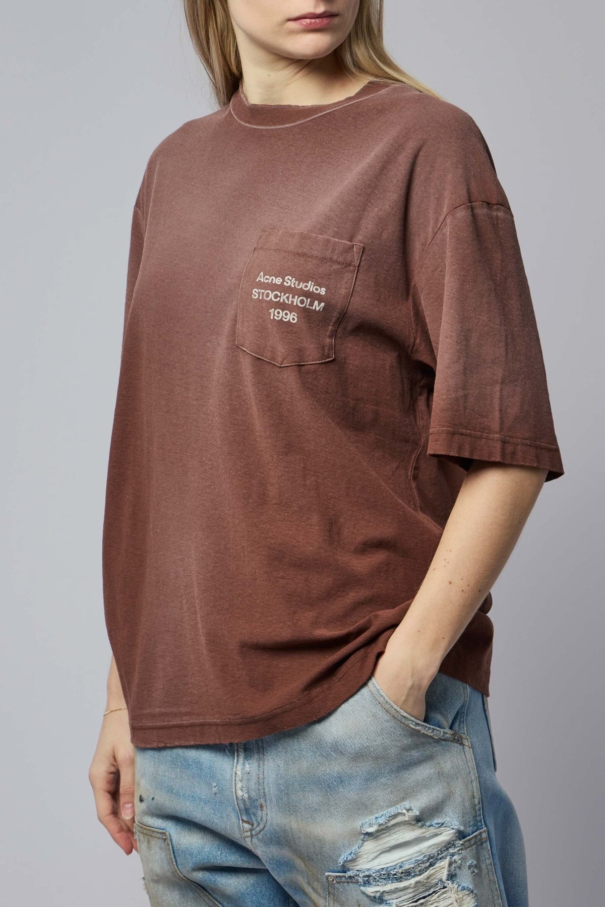Model wearing white Acne Studios logo pocket t-shirt with casual styling