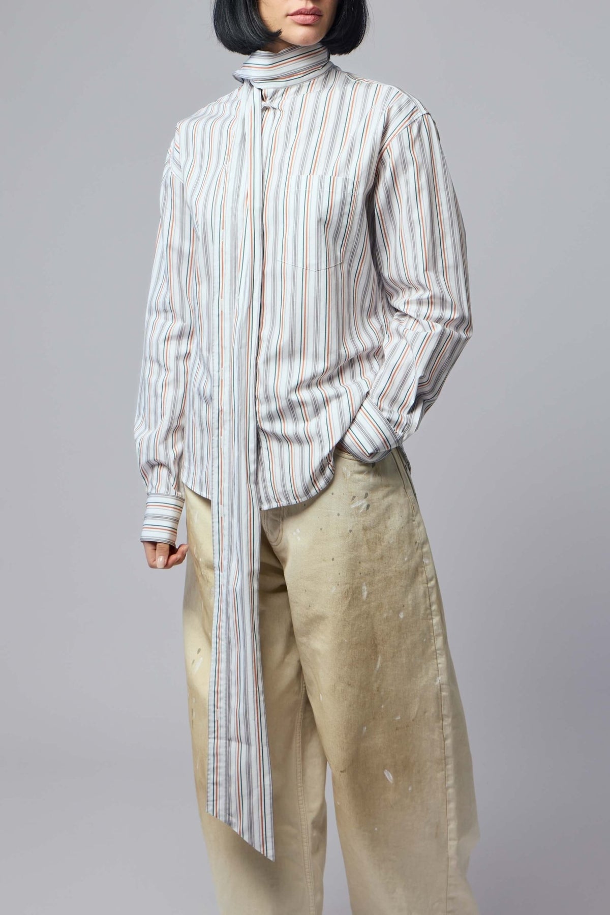 Model wearing Acne Studios striped blouse with sophisticated styling