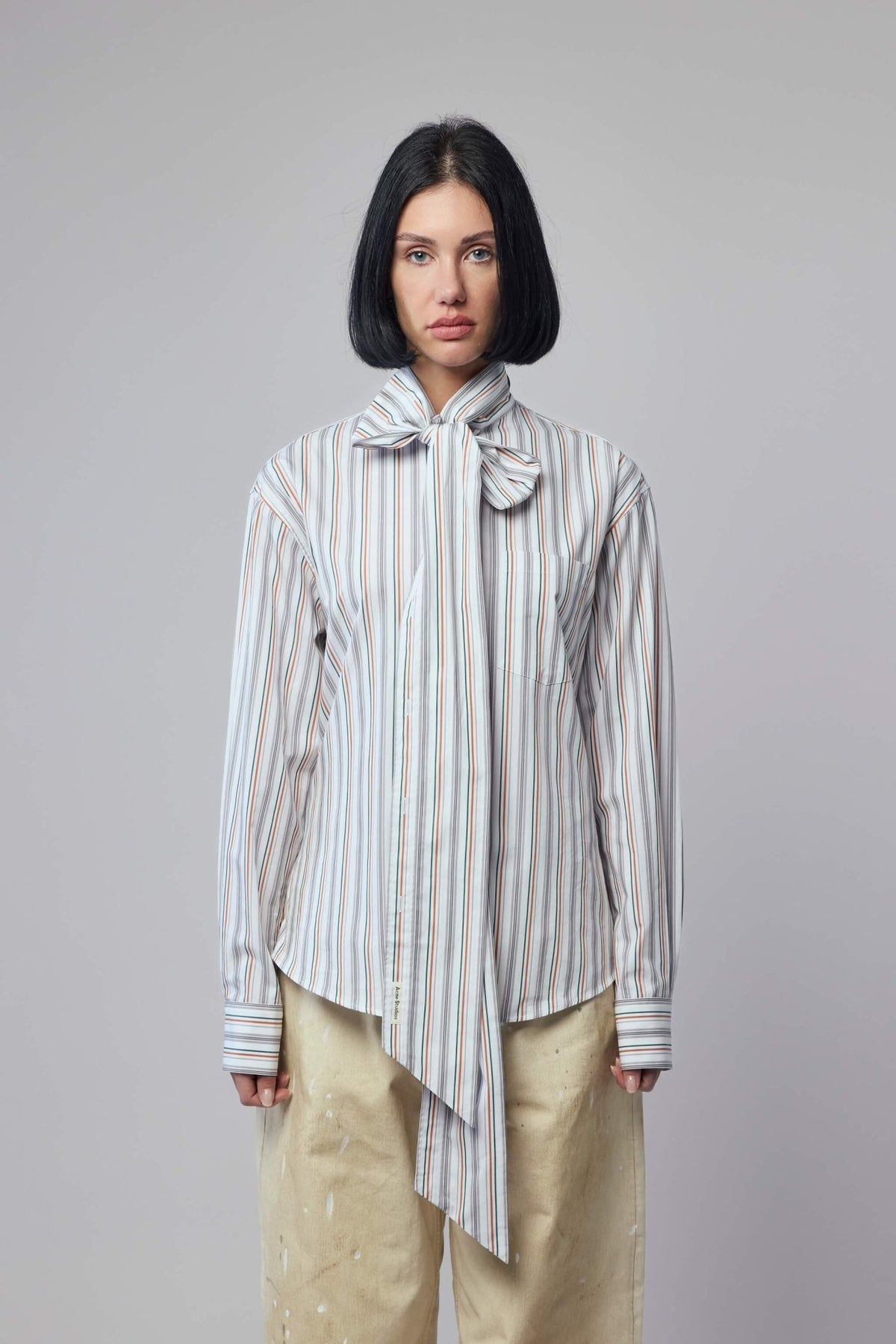 Close-up of striped pattern and bow tie detail on Acne Studios blouse