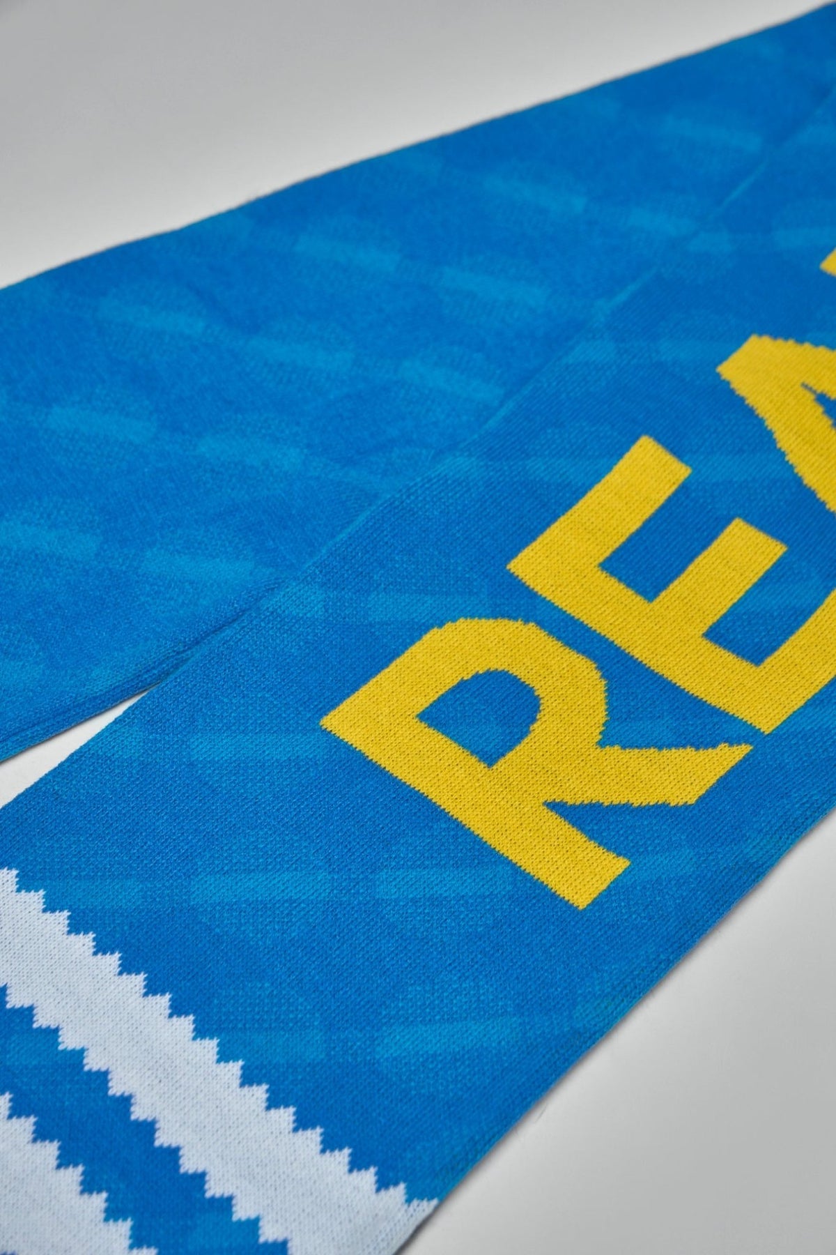 Detail shot of diagonal jacquard weave pattern on blue football scarf