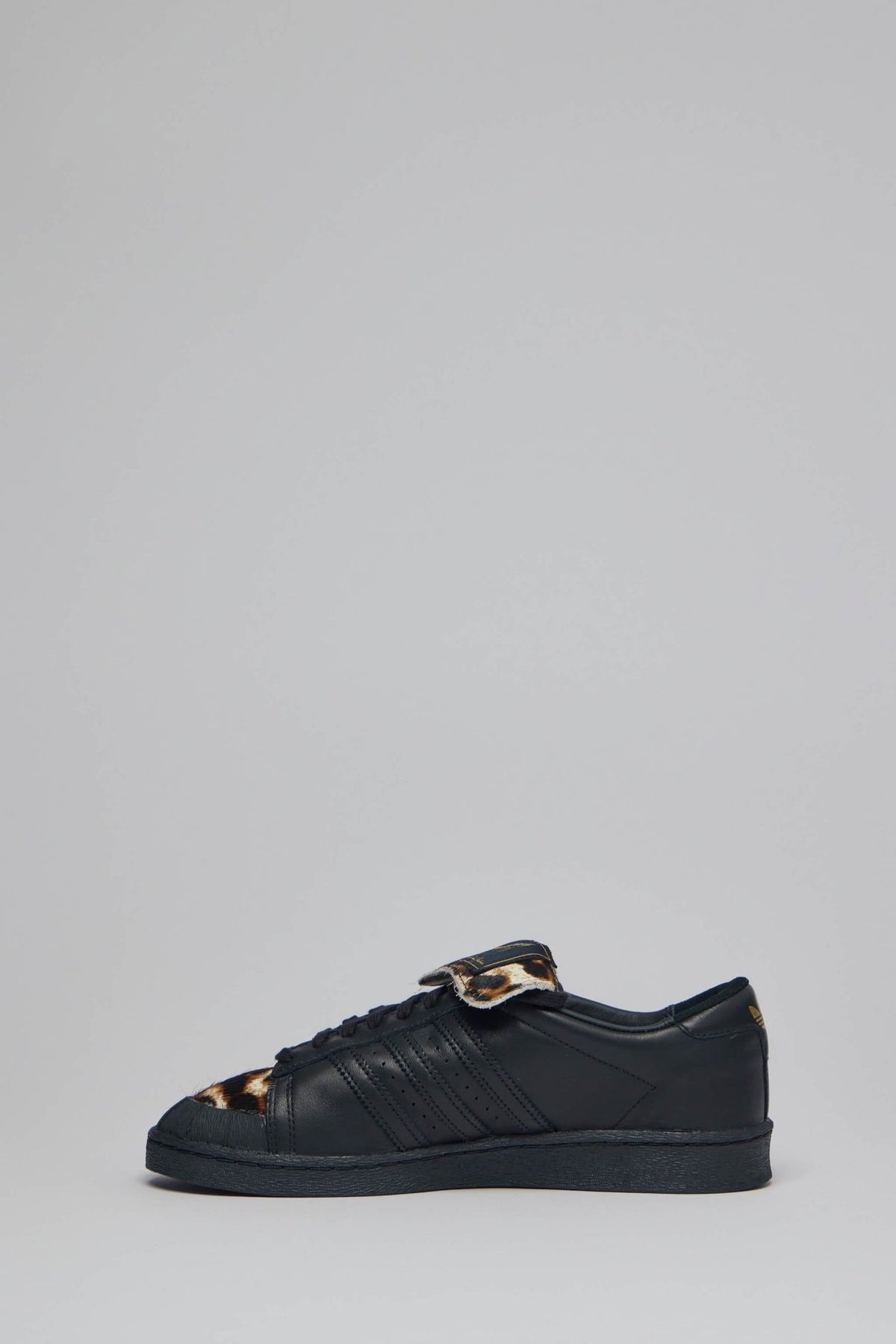Close-up of leopard print accents on black leather sneaker upper