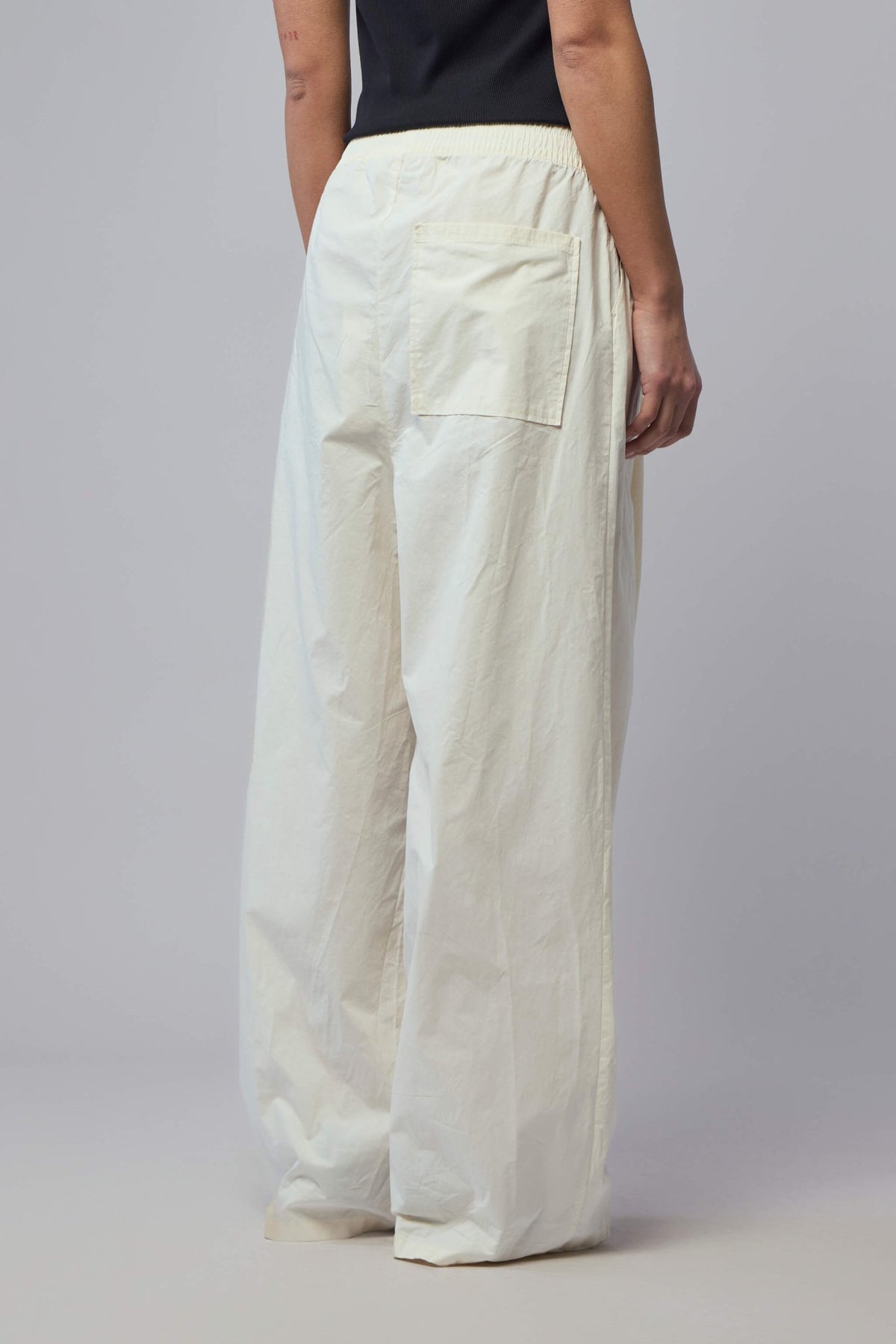 Back view of wide-leg pants showing minimal design and rear pocket