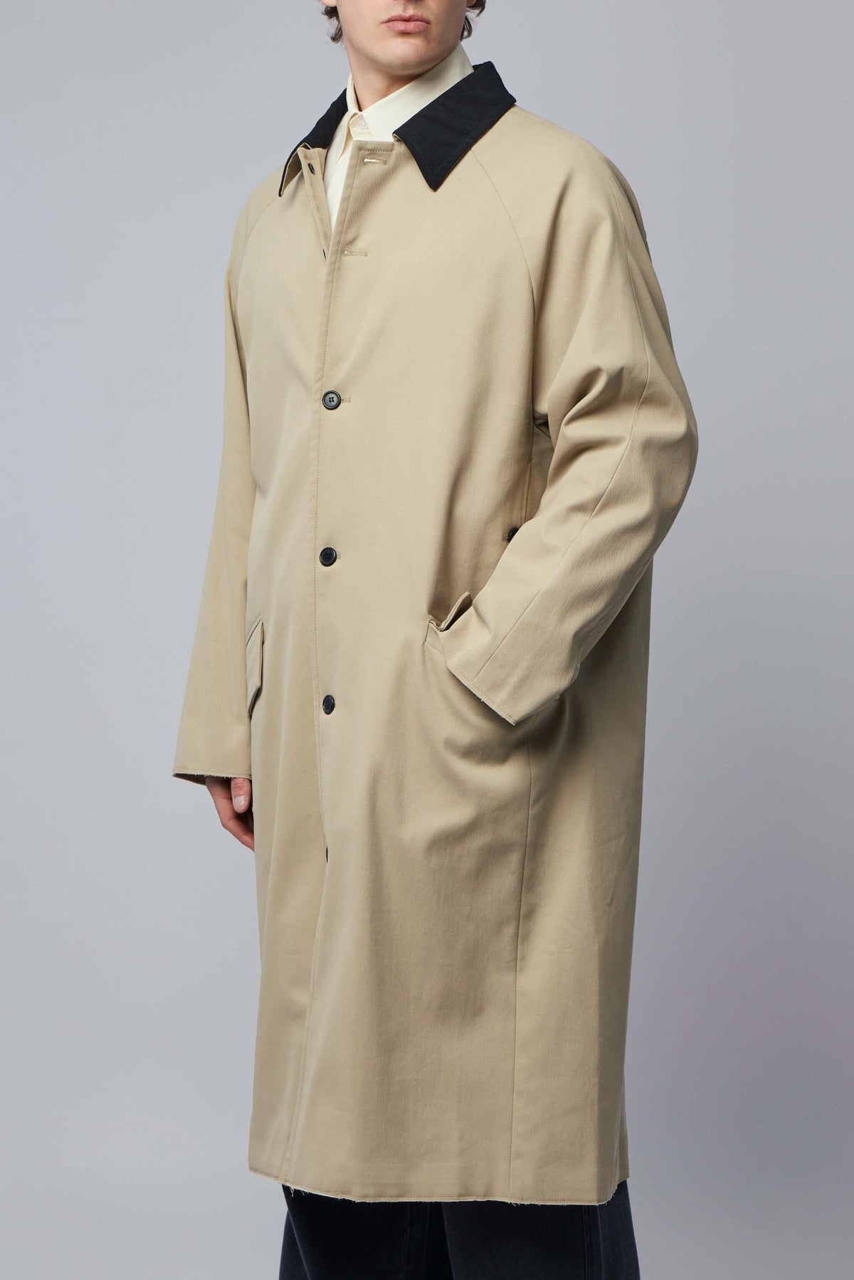 Side view showing long silhouette and side pockets of Rizwan coat