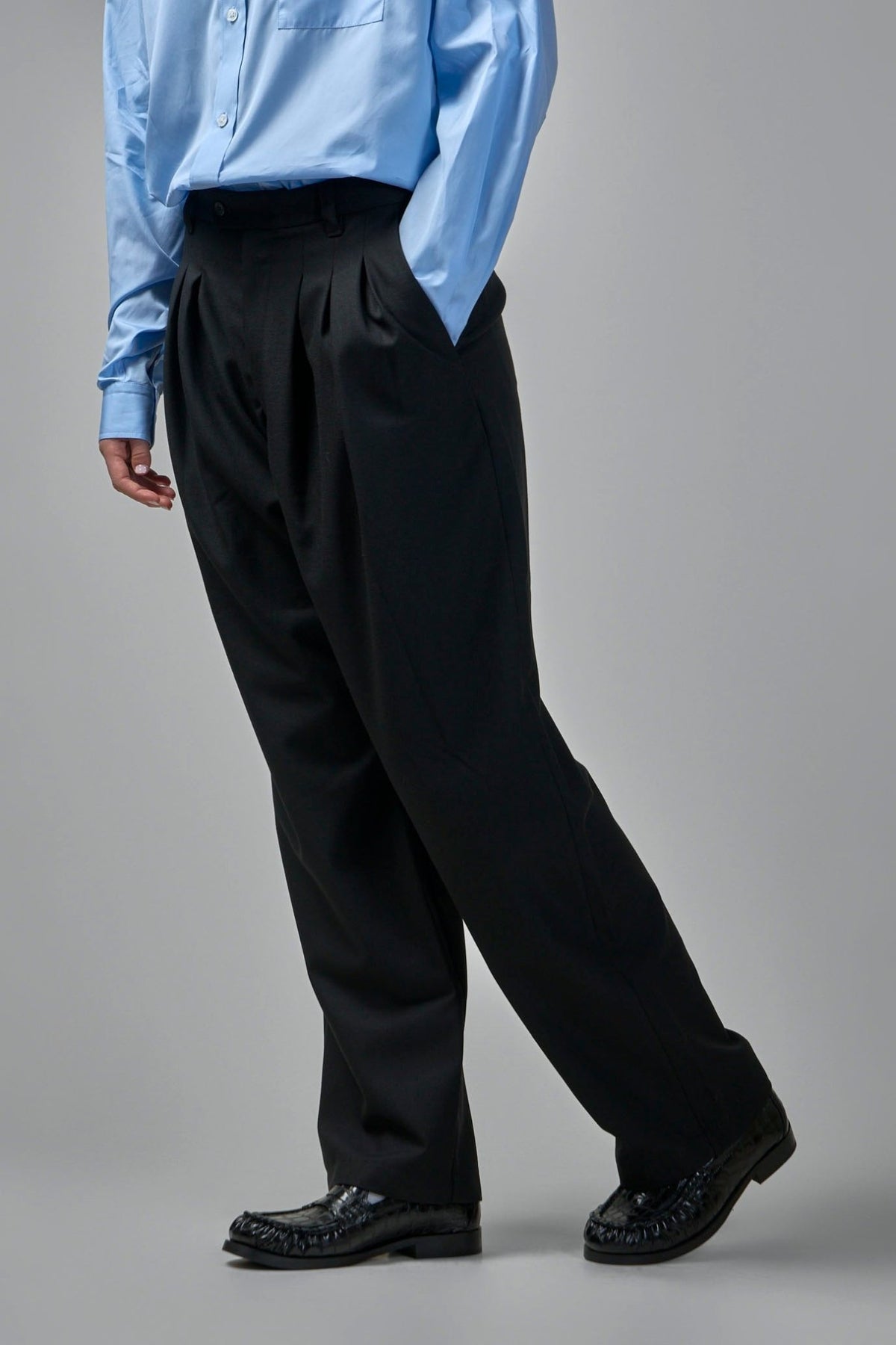 Detail view of Adnym wide-leg pants featuring button waistband and belt loops