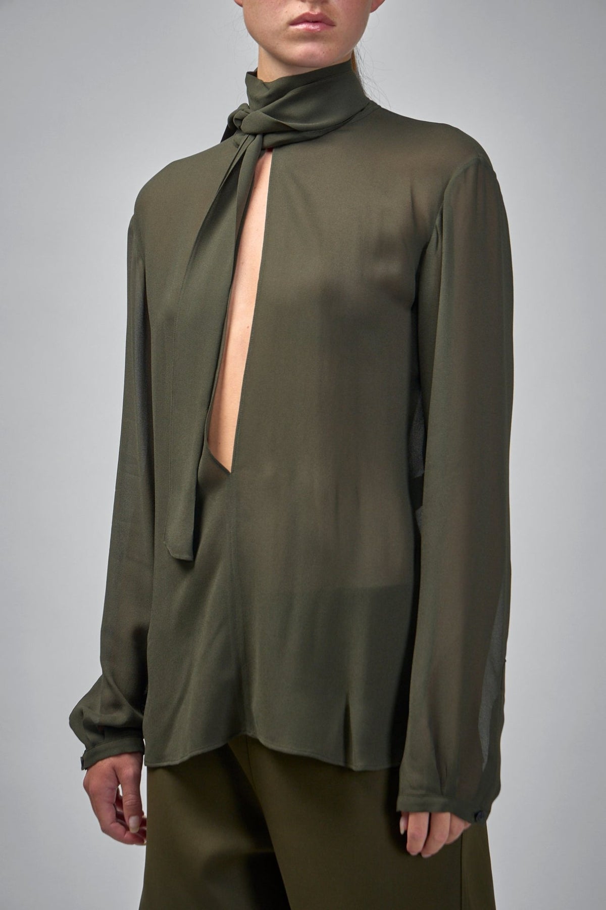 Detail shot of Alaïa blouse construction showing seamless shoulders and flowing drape
