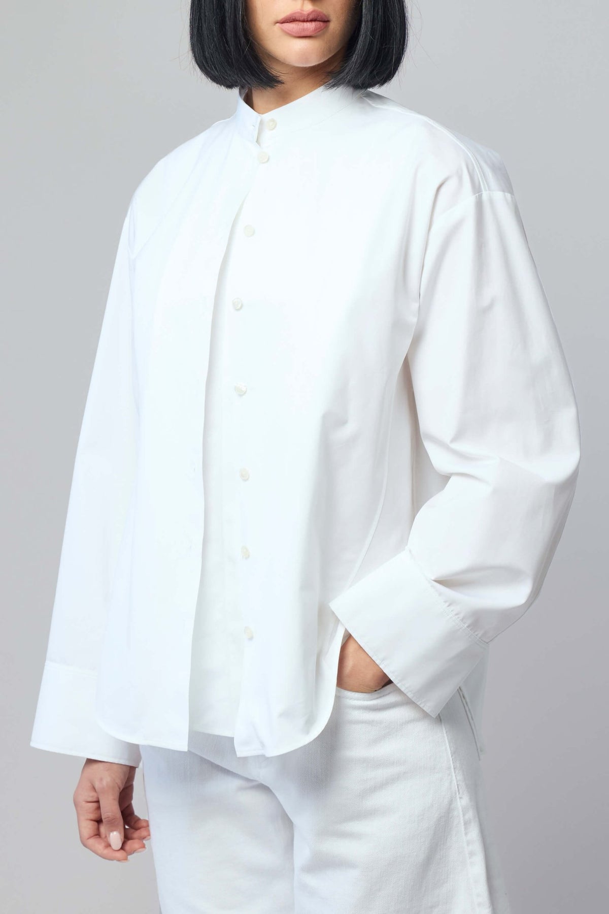Model wearing Alaïa layered shirt poplin blouse styled with trousers