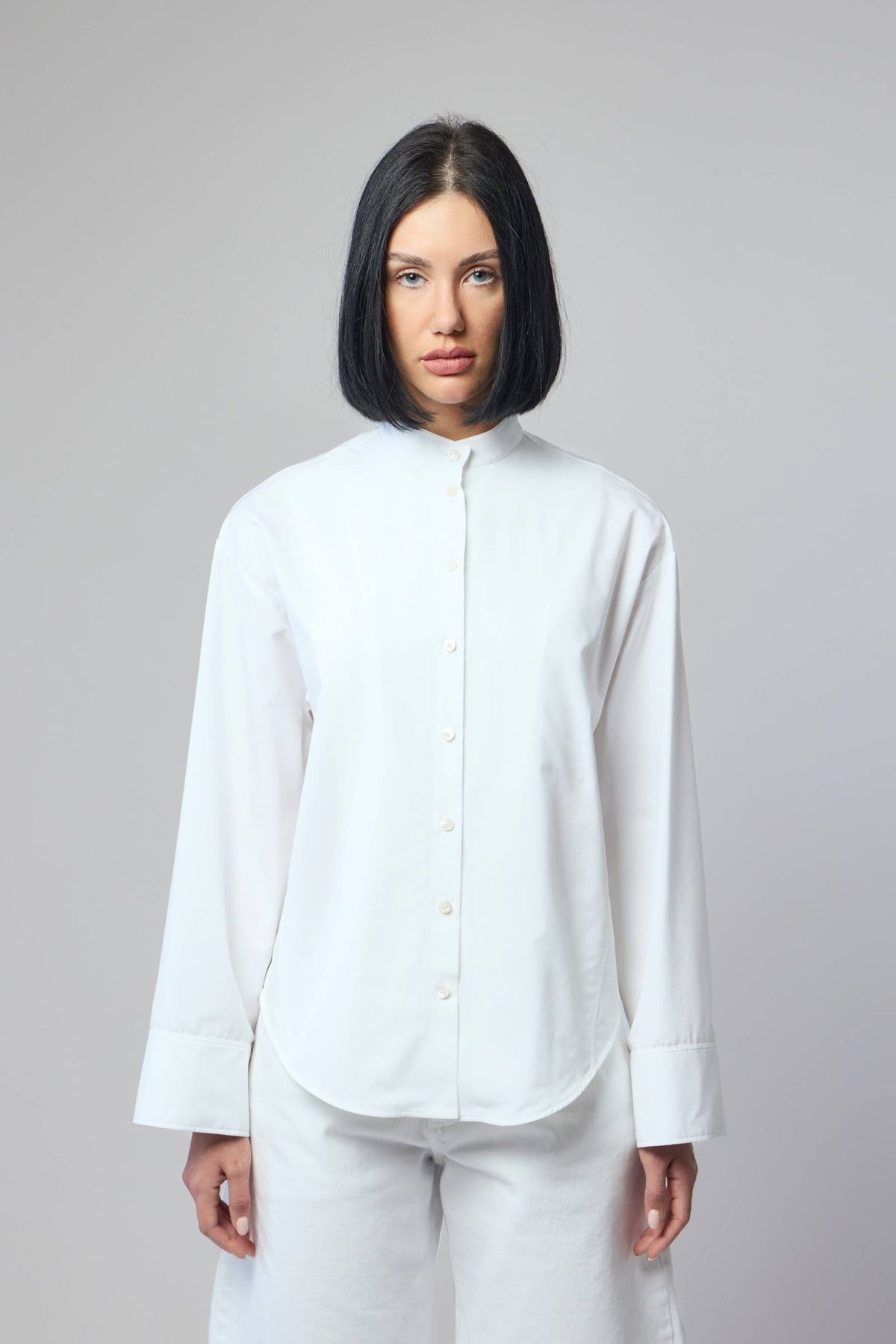 Close-up of button-front closure detail on Alaïa cotton blouse