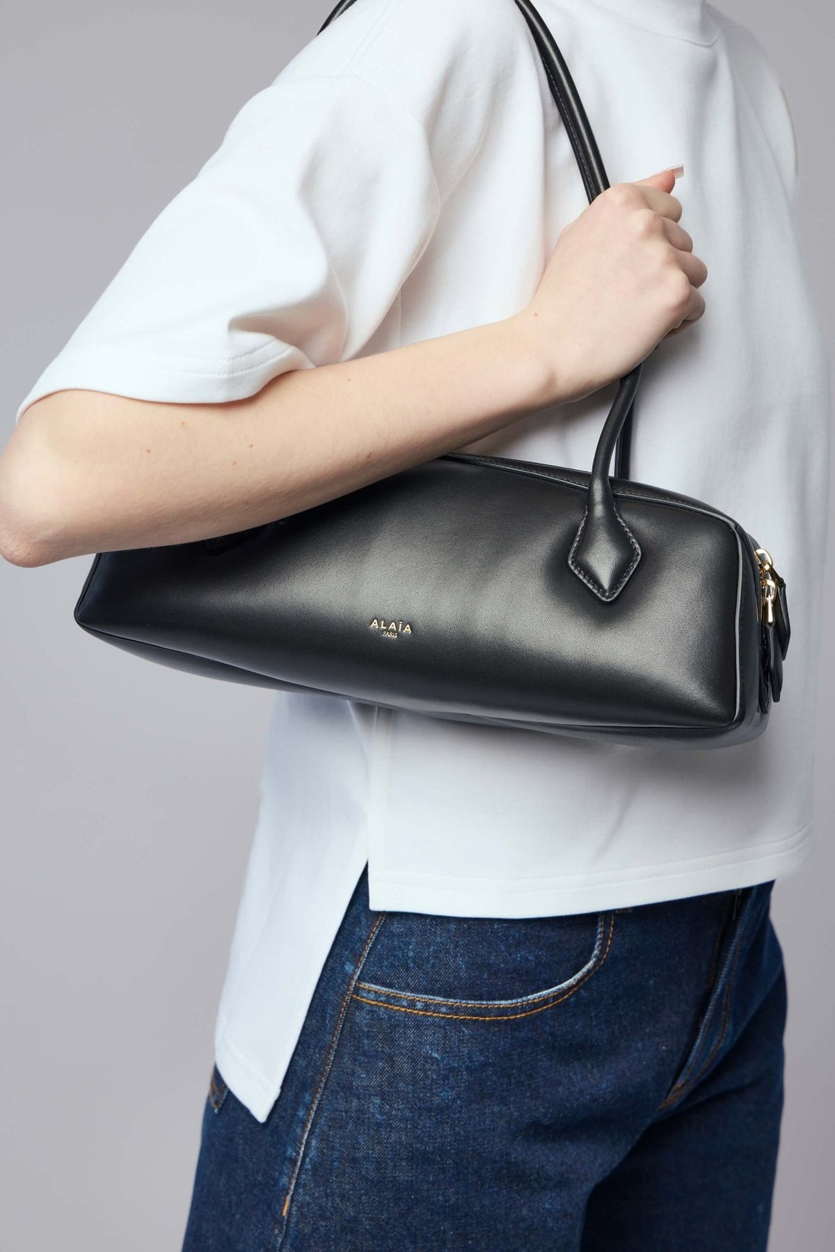 Detail shot of gold-tone zip closure on Alaïa shoulder bag