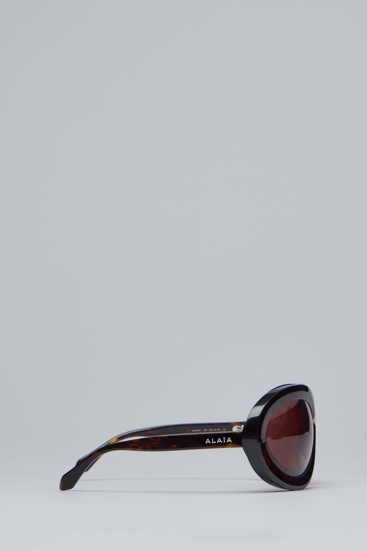 Model wearing Alaïa tortoiseshell sunglasses with bold tinted lenses