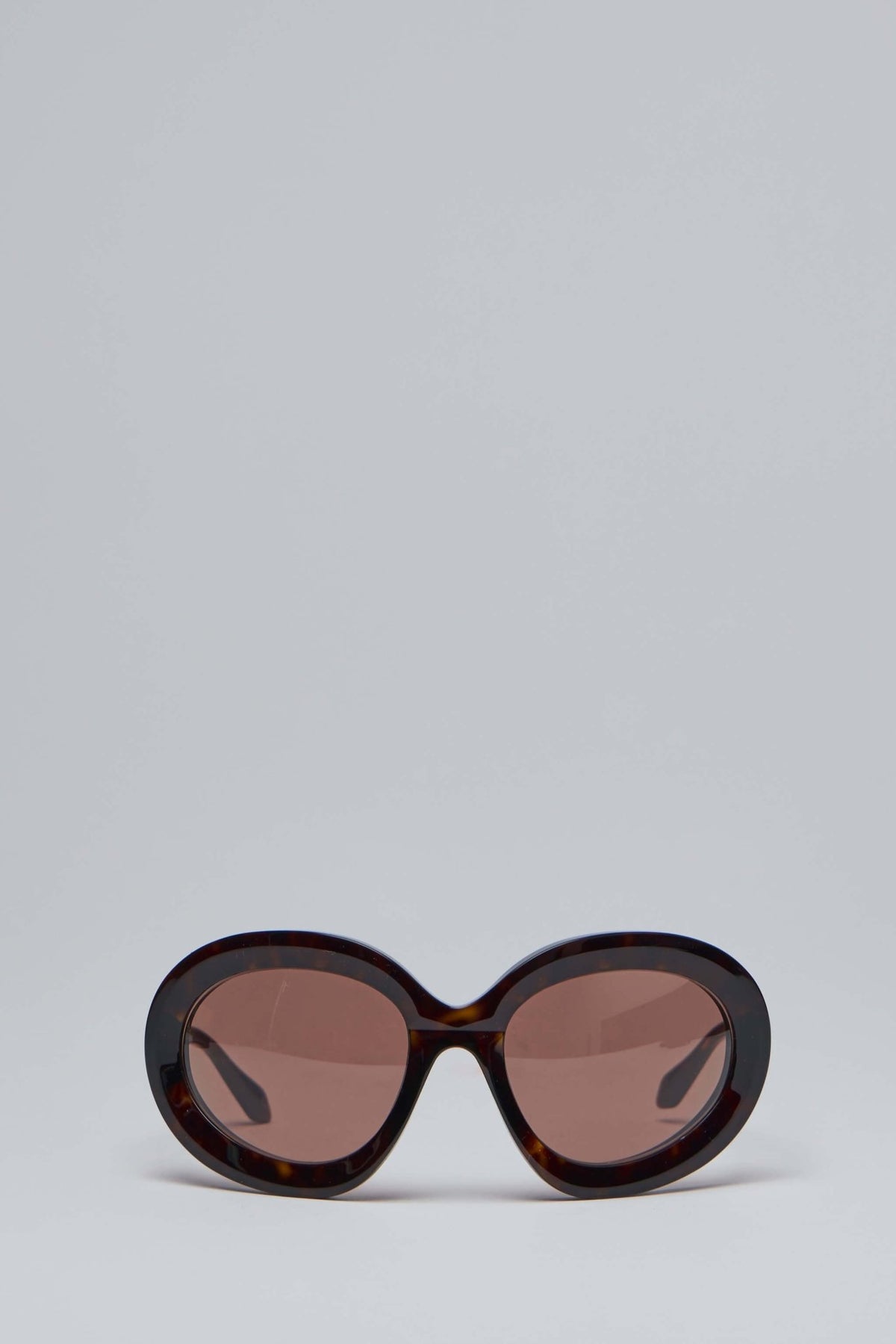 Alaïa sunglasses with oversized oval tortoiseshell frame and tinted lenses