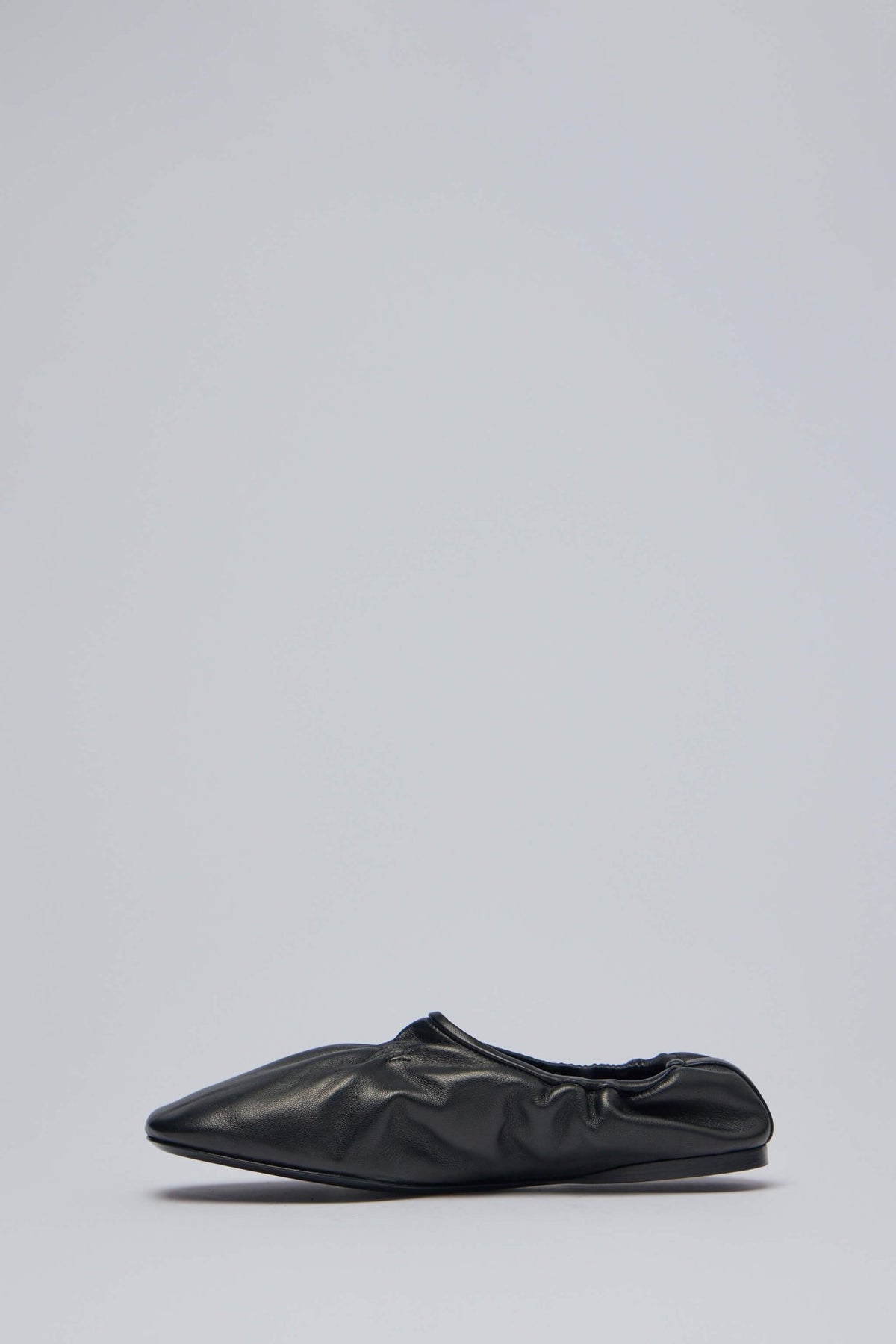 Side profile of Alaïa flats displaying sleek silhouette and elasticated trim