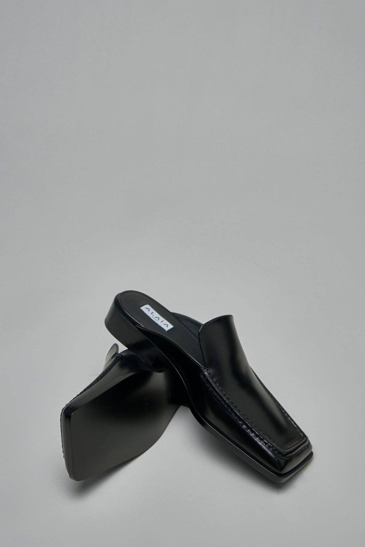Alaïa black leather mules styled with contemporary outfit