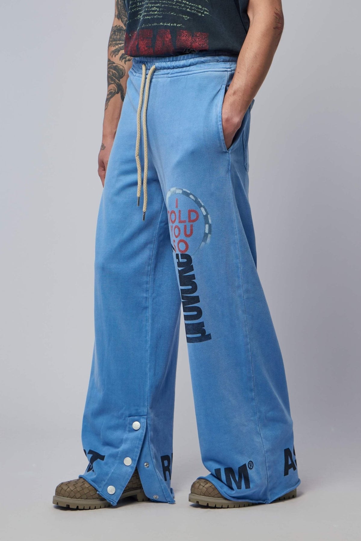 Side view showing elastic waistband and drawstring closure on blue track pants