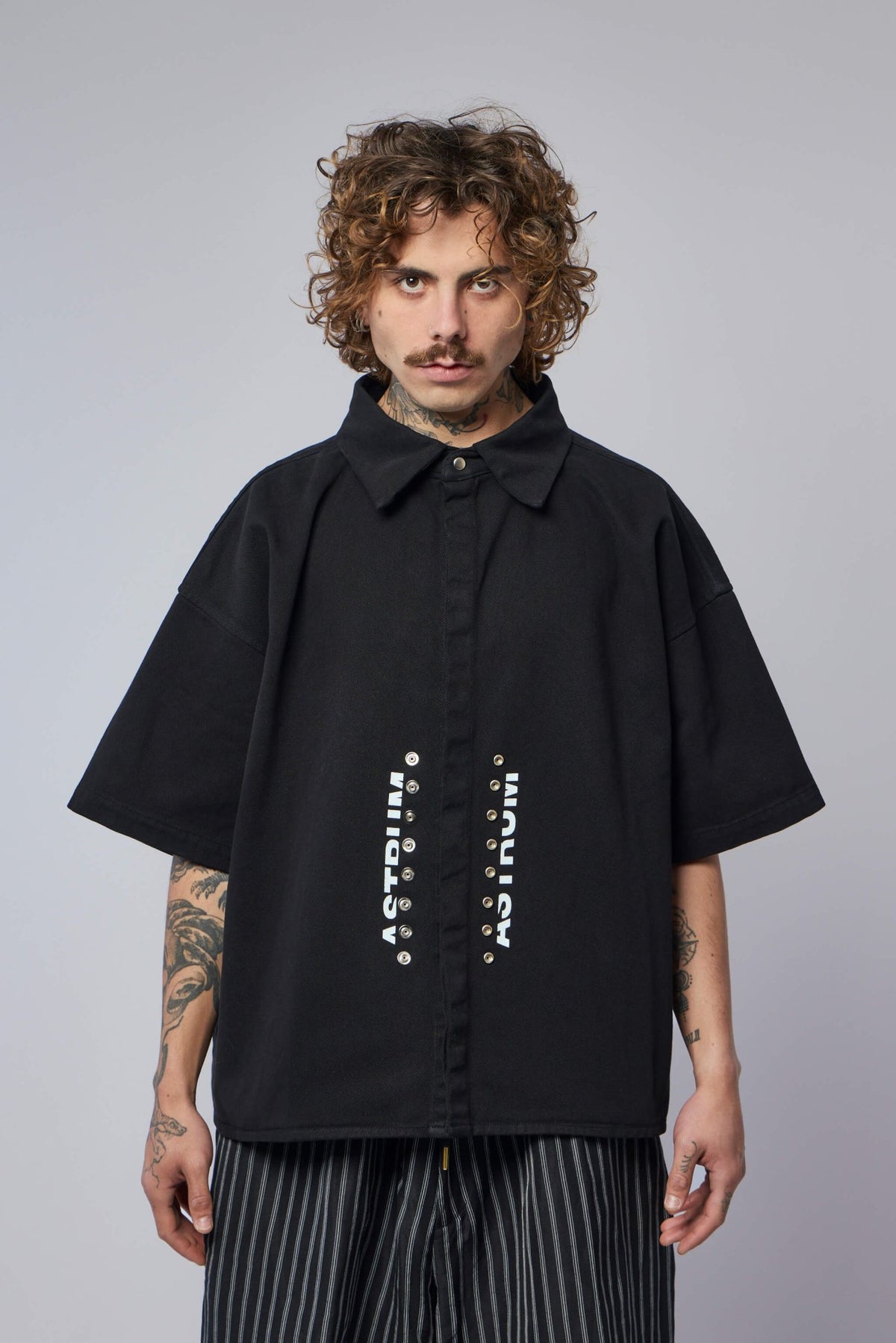 Close-up of industrial metal snap closure details on Astrum shirt