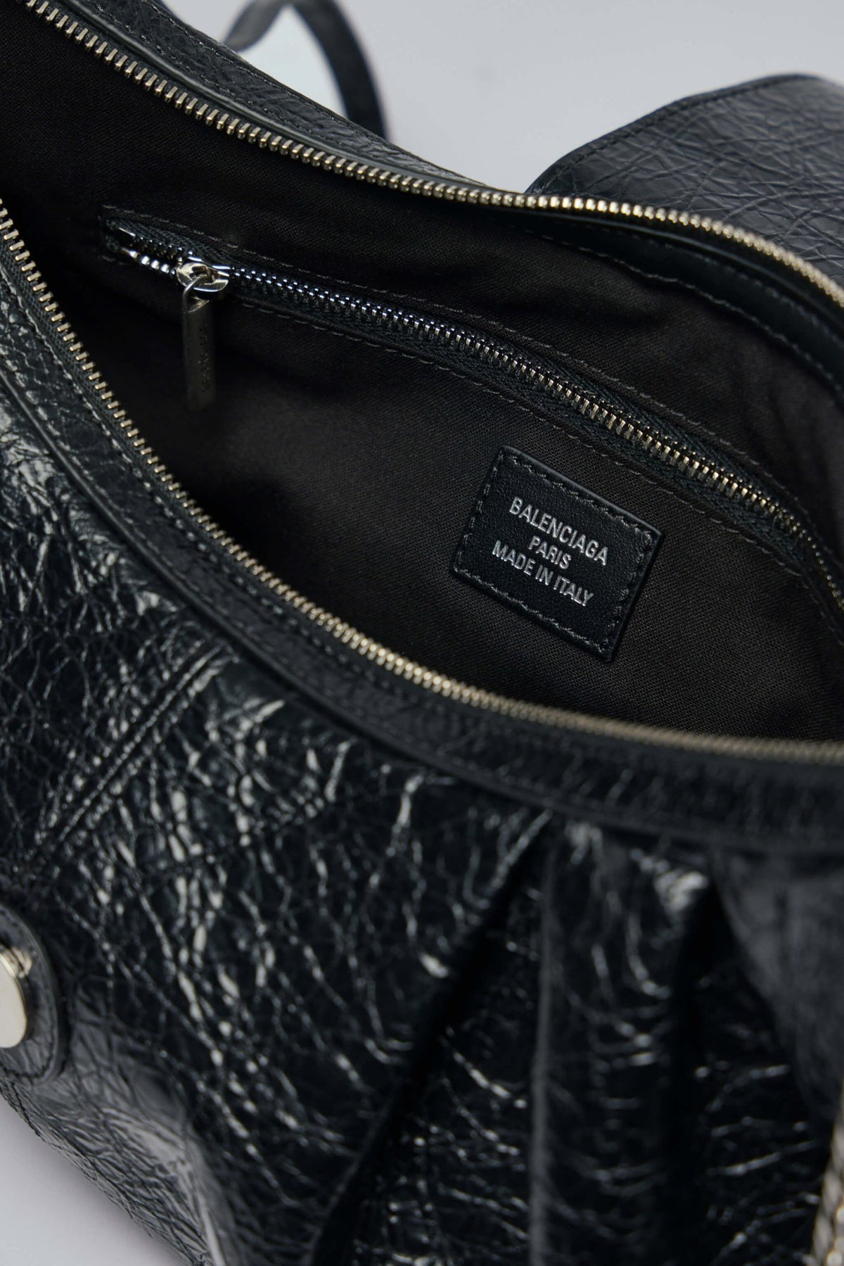 Side profile of Pamela M bag showcasing crinkled leather texture and chain strap