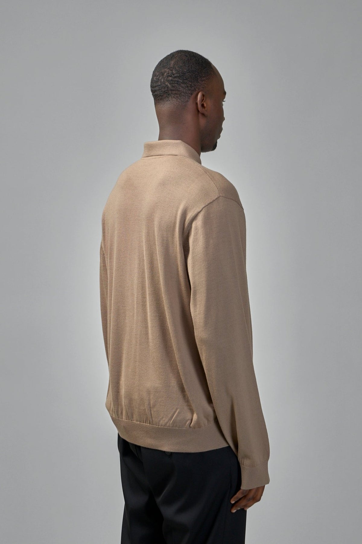 Model wearing beige Balenciaga wool poloneck sweater, relaxed fit styling