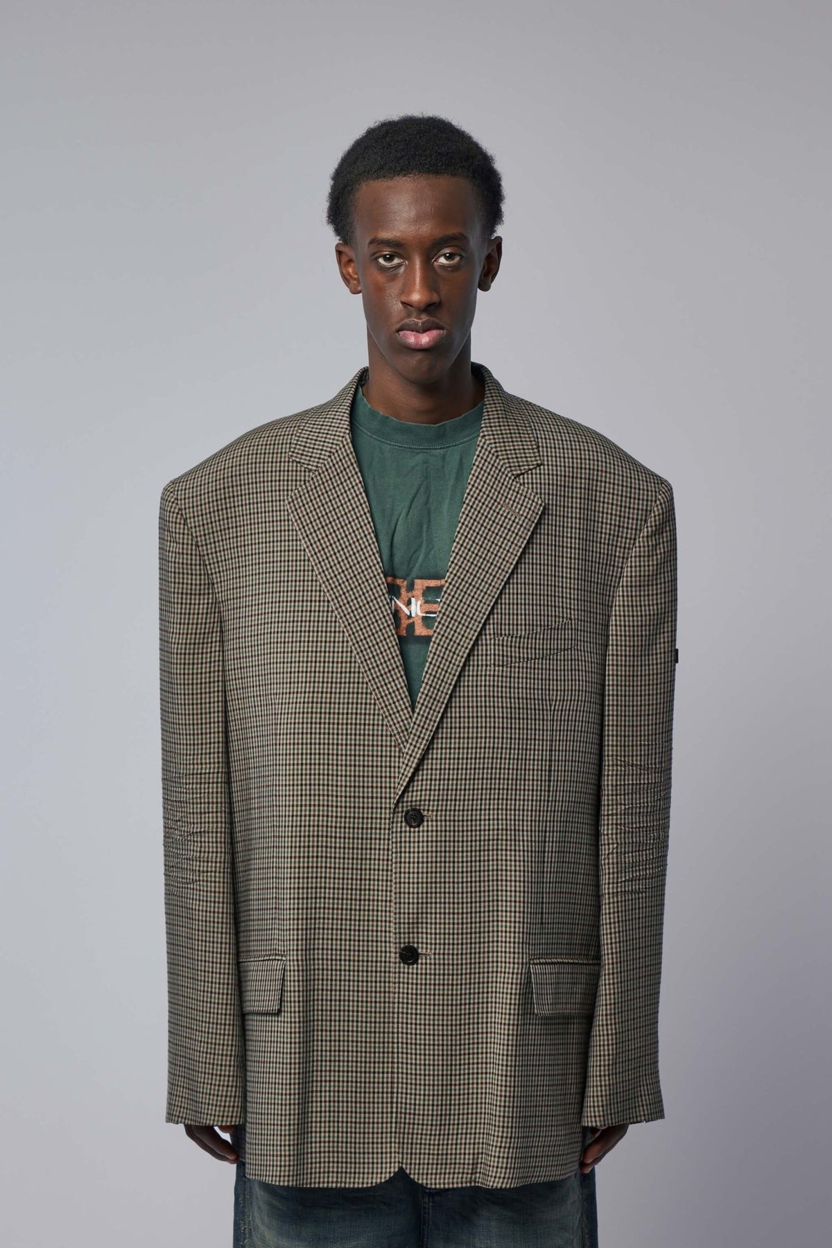 Close-up of Balenciaga embroidered patch detail on houndstooth blazer lapel