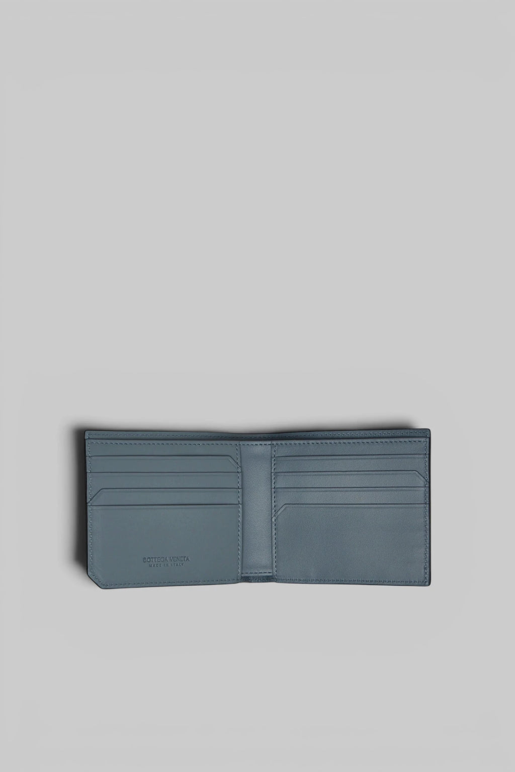 Bottega Veneta leather wallet held in hand for scale reference