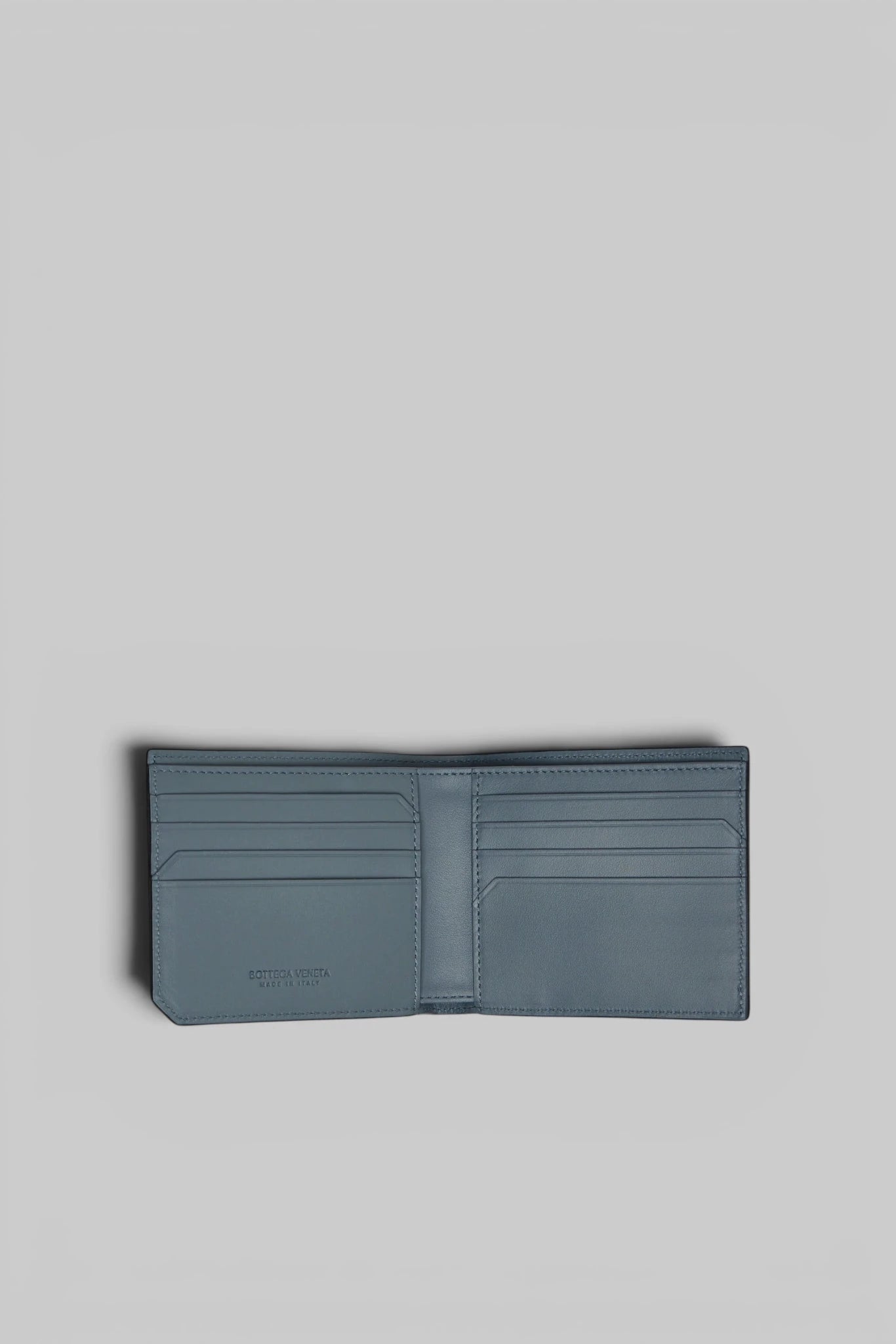 Bottega Veneta leather wallet held in hand for scale reference