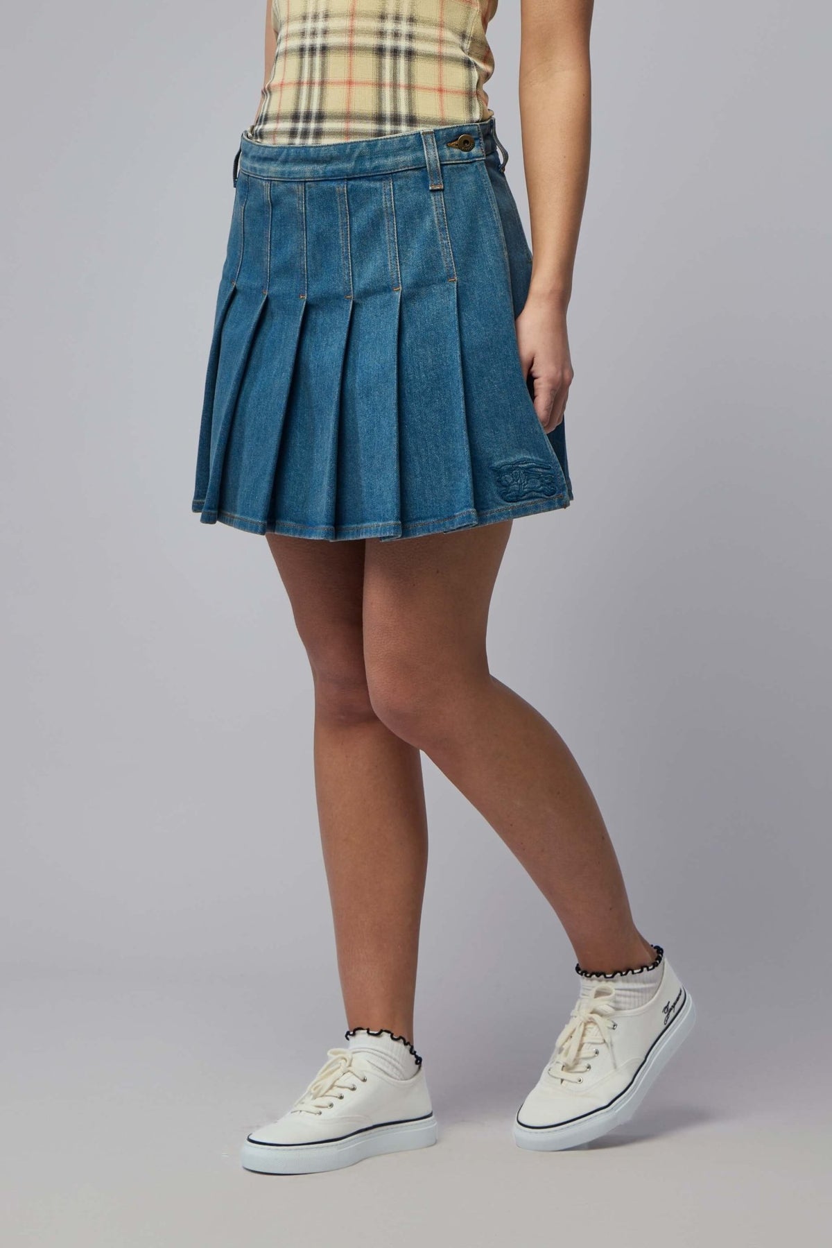 Side view showing embroidered Burberry logo detail on mini skirt