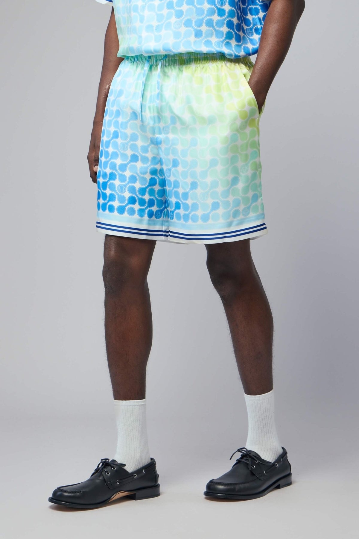 Model wearing Casablanca Tennis Tile Silk Shorts styled casually