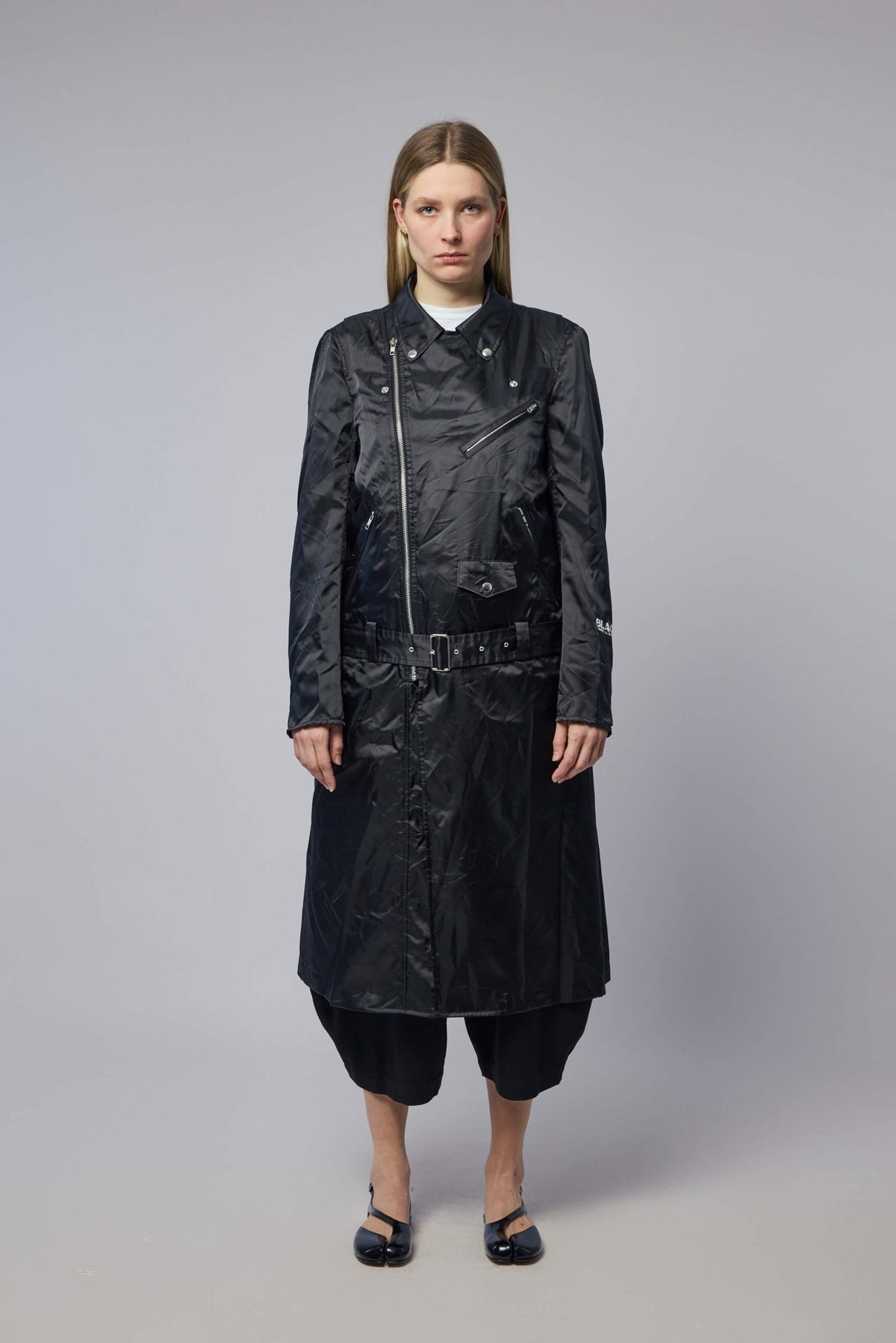 Model wearing black polyester coat with notched lapel collar and metallic buttons