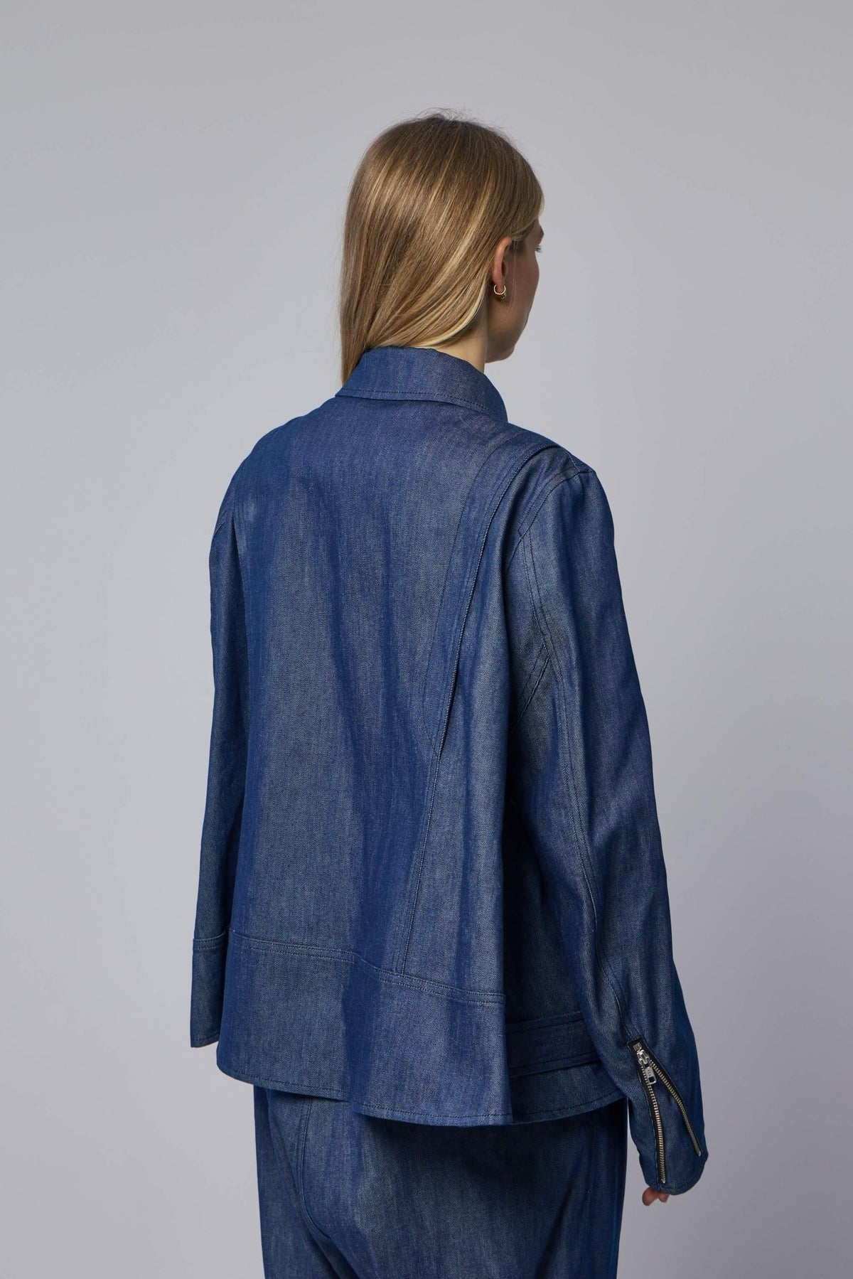 Model wearing Comme des Garçons blue denim jacket with belted waist