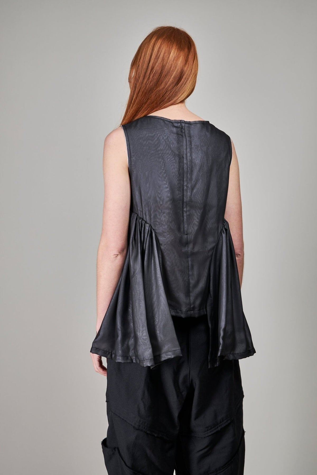 Model wearing Comme des Garçons black minimalist blouse