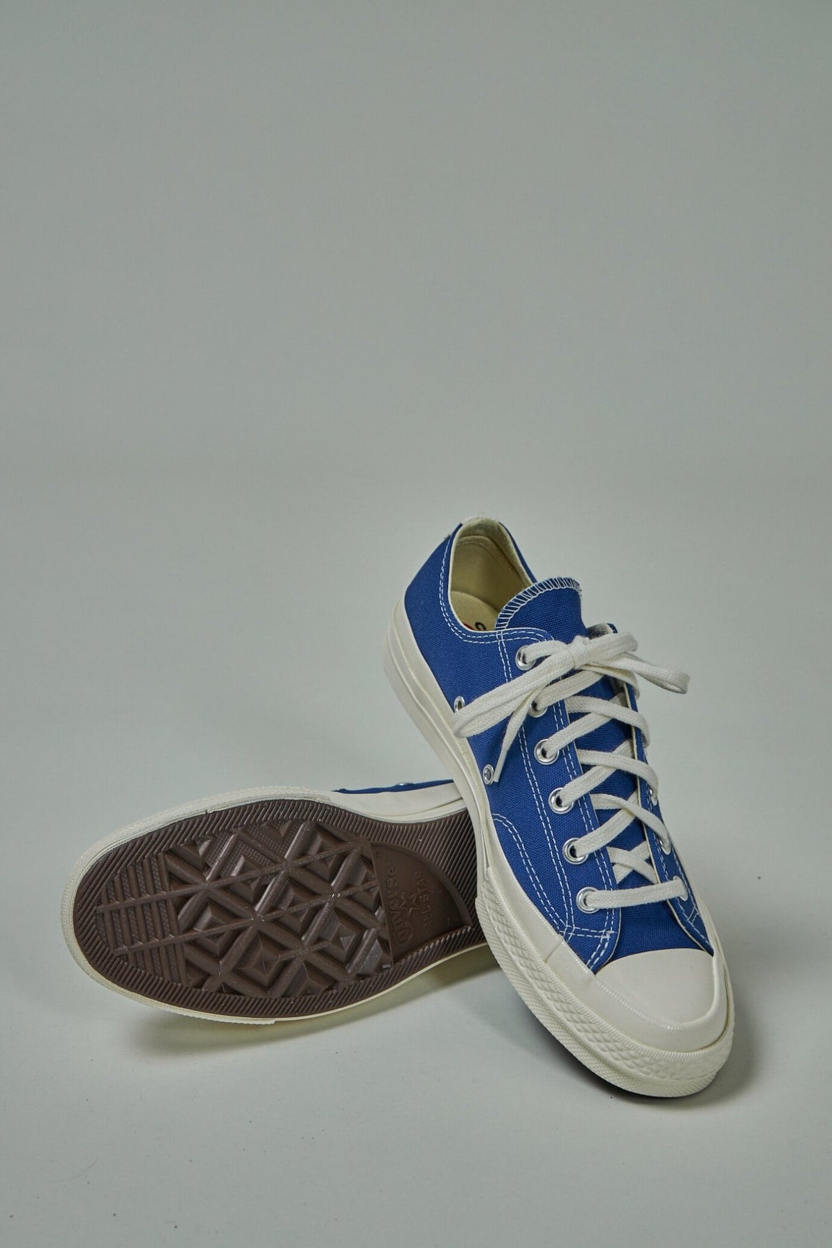 Complete pair of CDG PLAY Converse sneakers on white background
