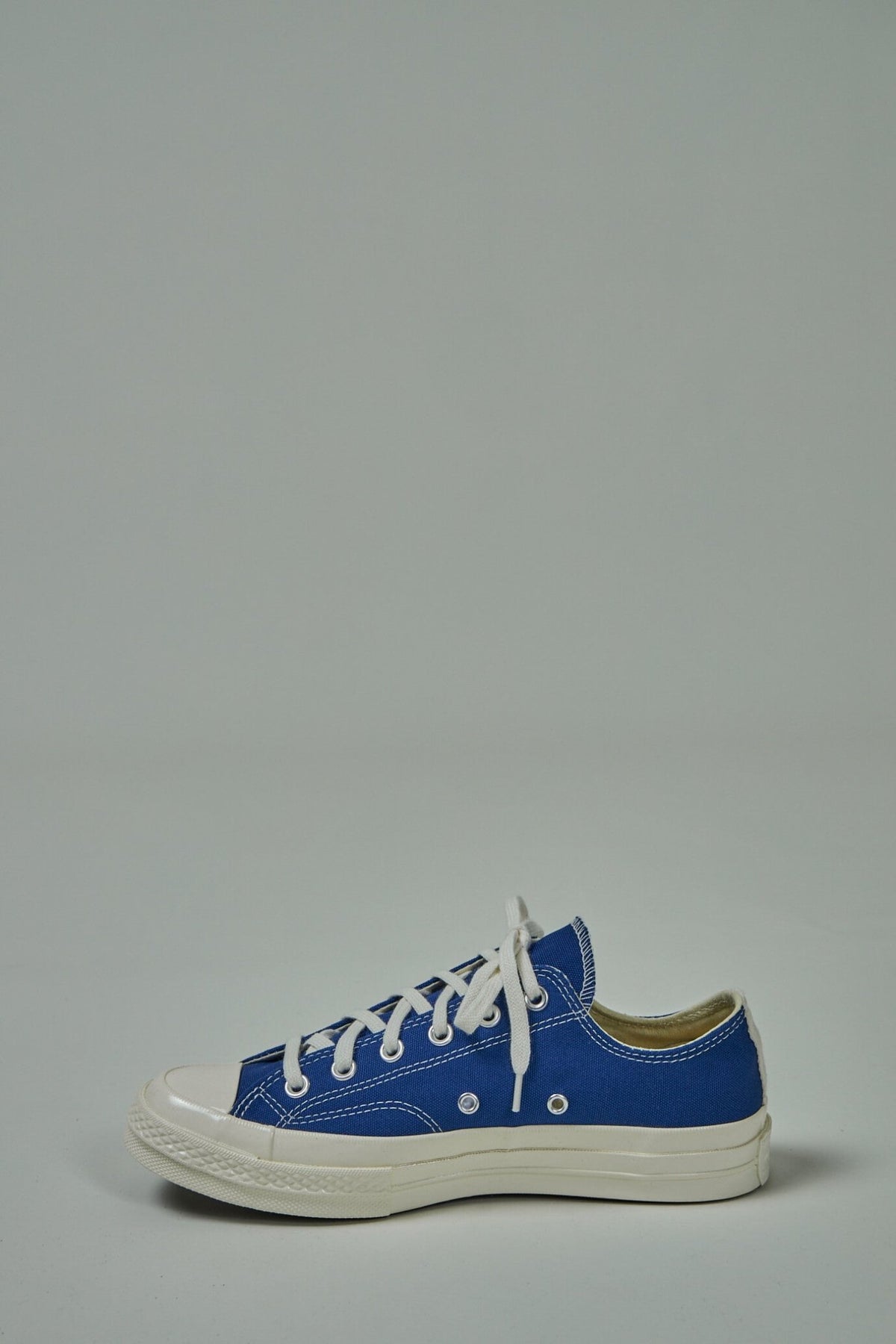Heel detail of Comme des Garçons PLAY heart logo on white sneakers