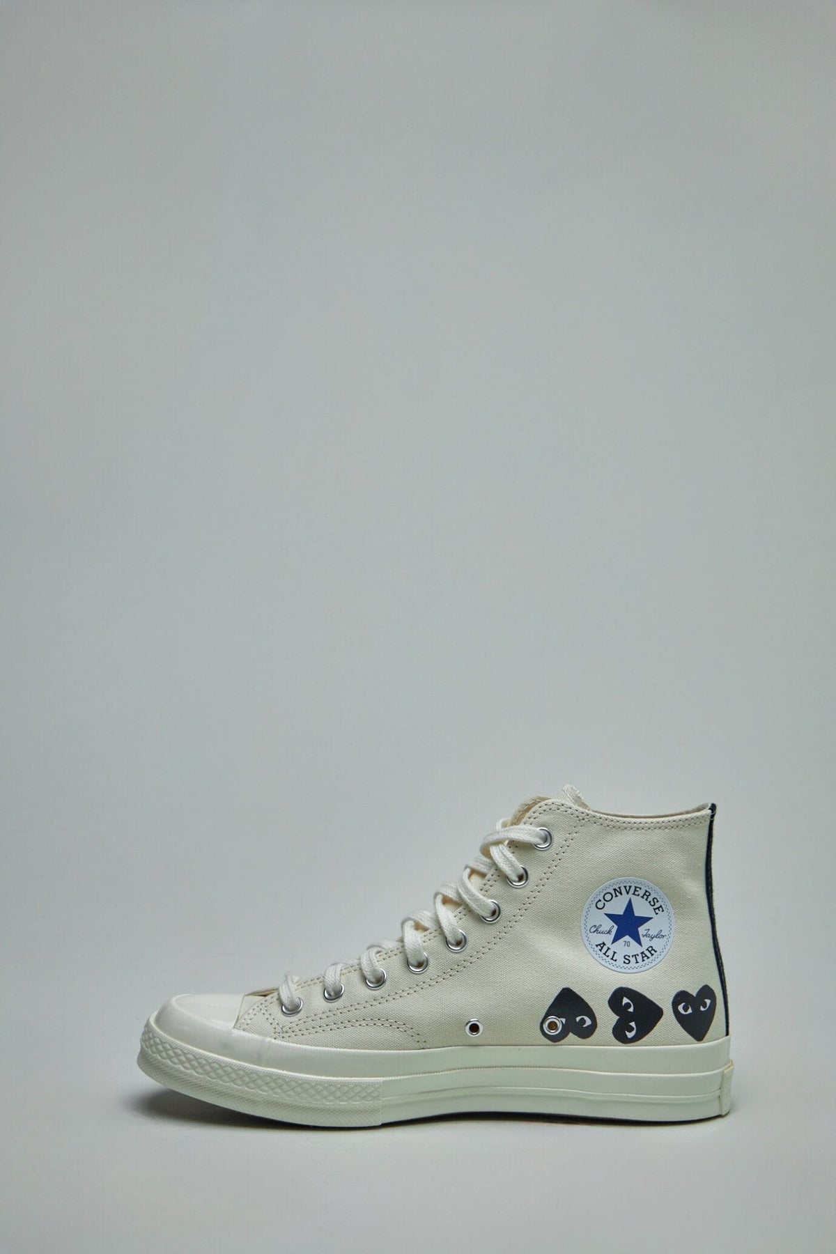 Close-up detail of iconic heart logos on Comme des Garçons PLAY sneakers