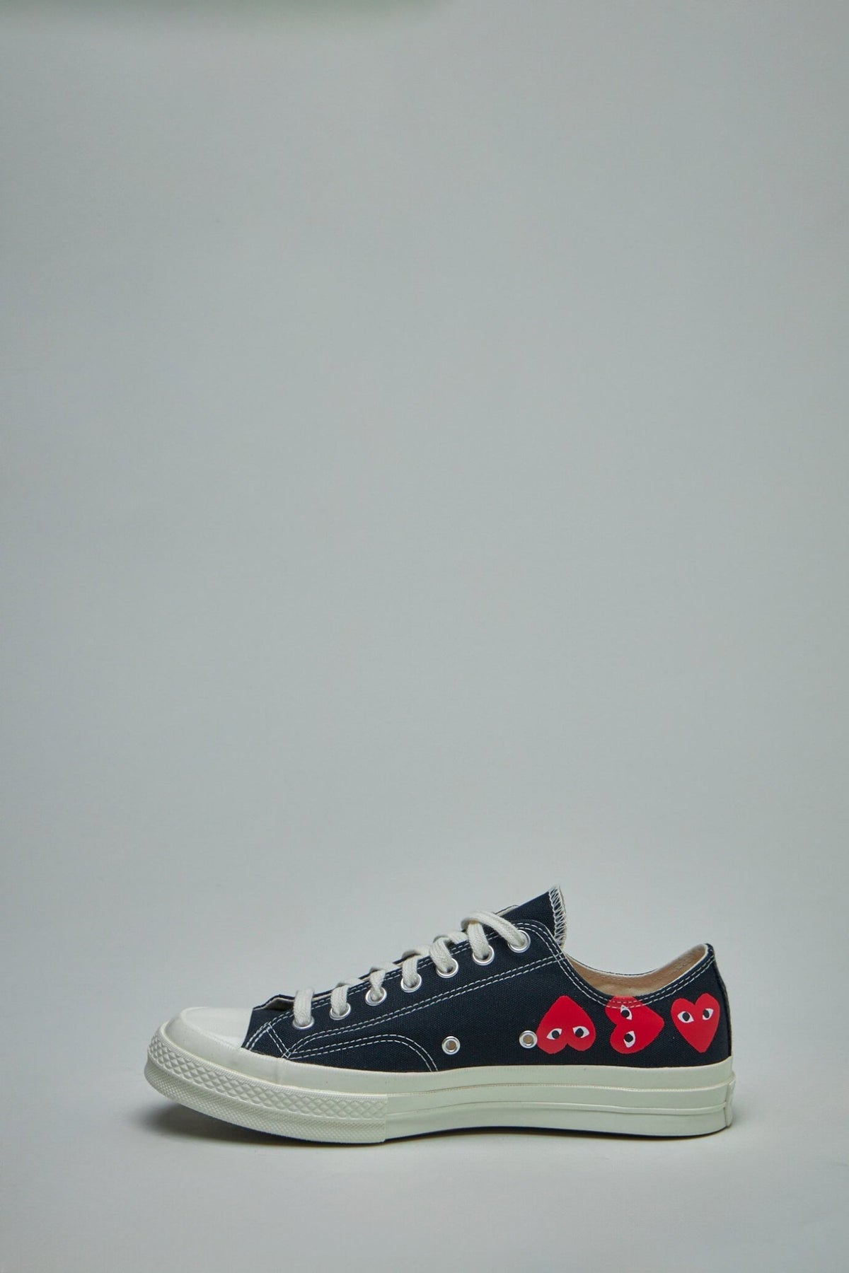 Front view of white low top sneakers with multiple heart logos