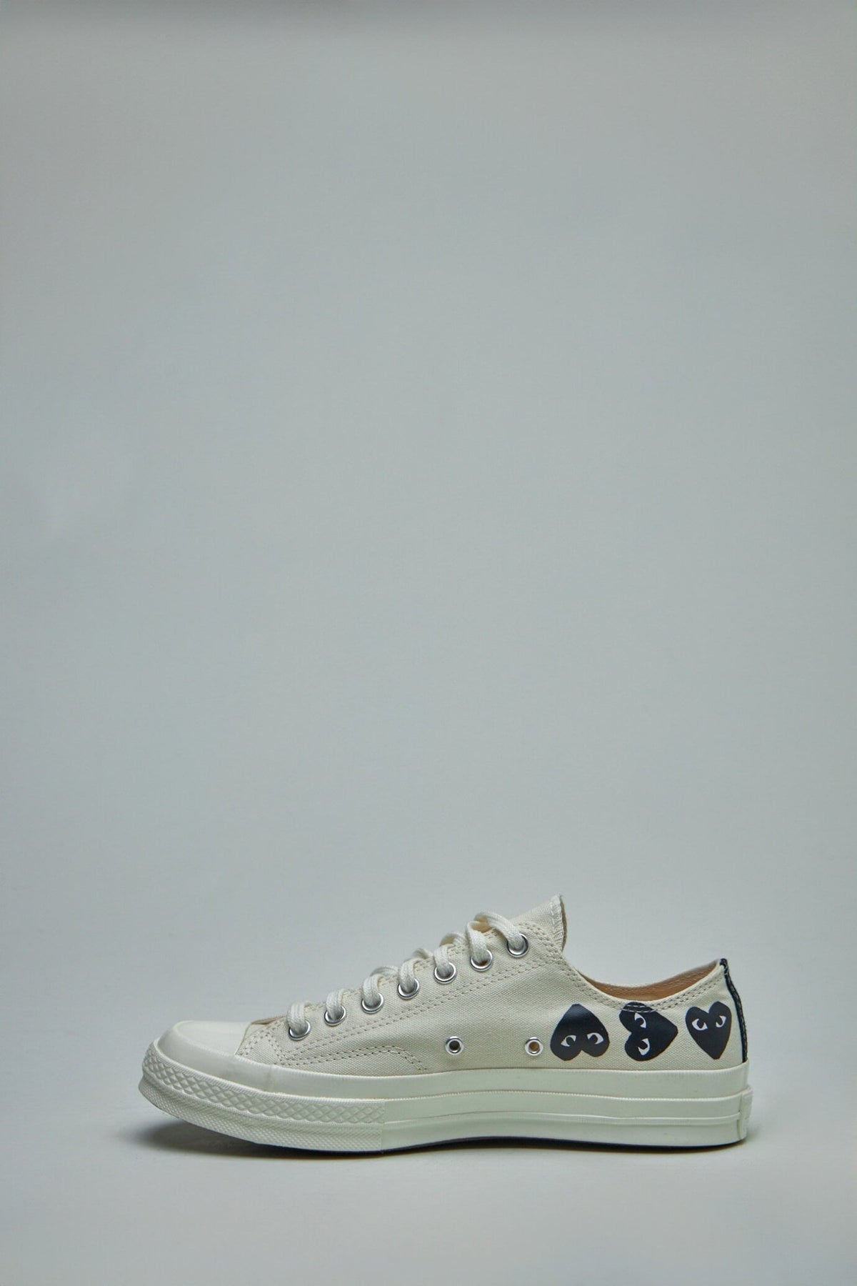 Detail shot of multi-heart embroidery on Converse collaboration sneakers