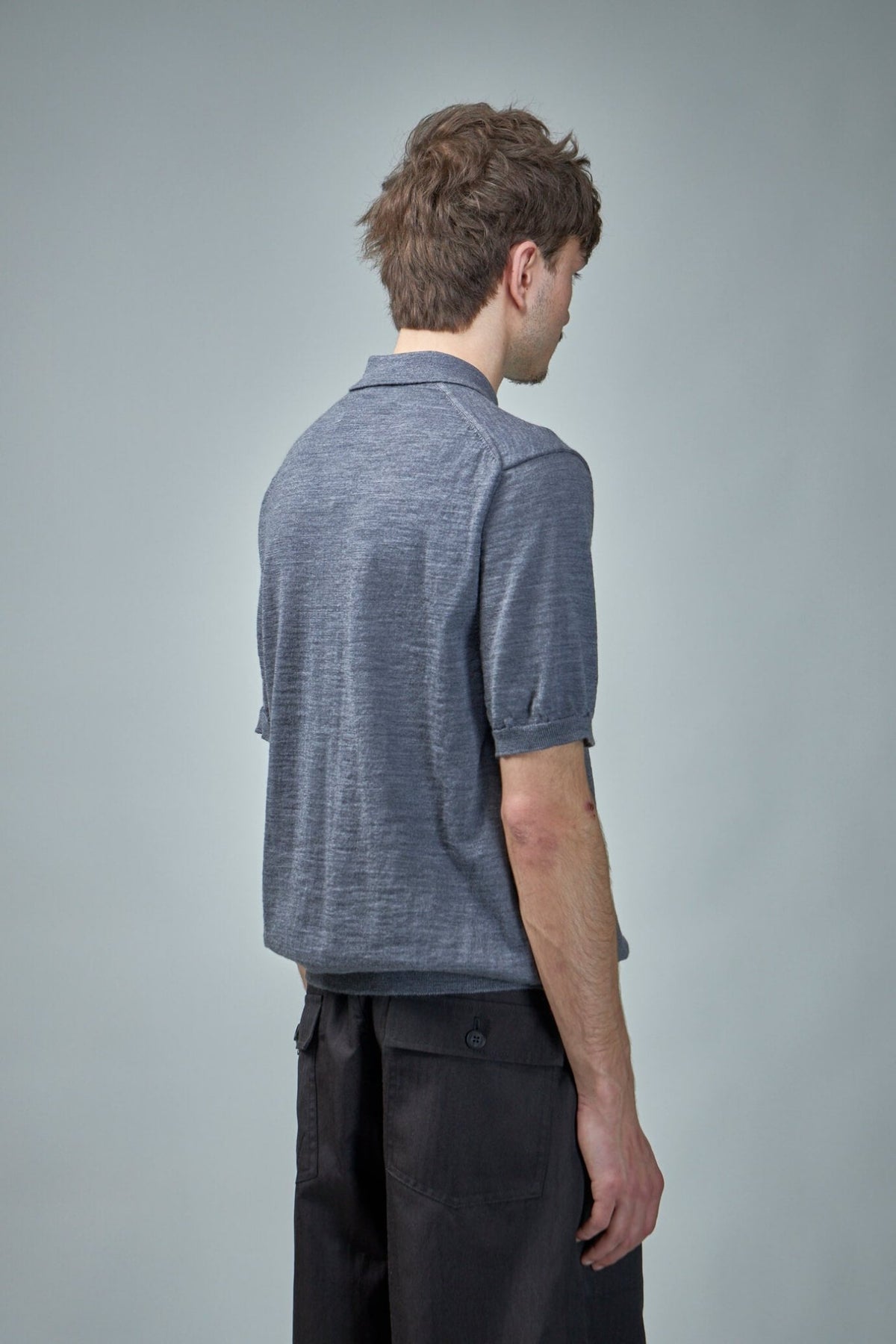 Model wearing grey Comme des Garçons PLAY polo with short sleeves