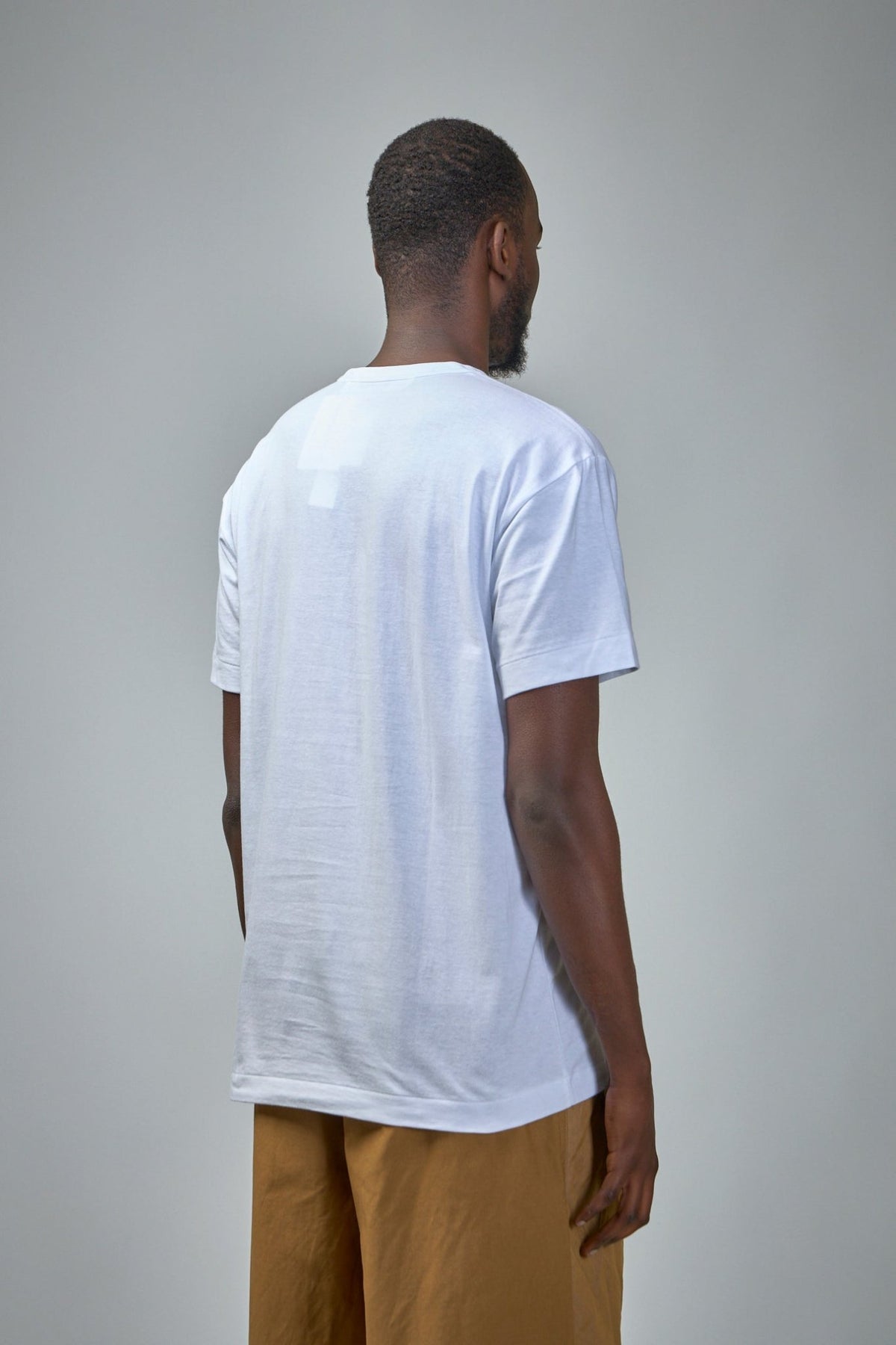 Model wearing Comme des Garçons PLAY logo stud print t-shirt, front view