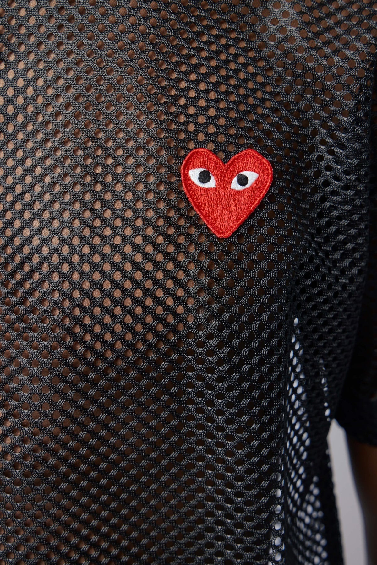 Side view of red mesh t-shirt showing fabric texture
