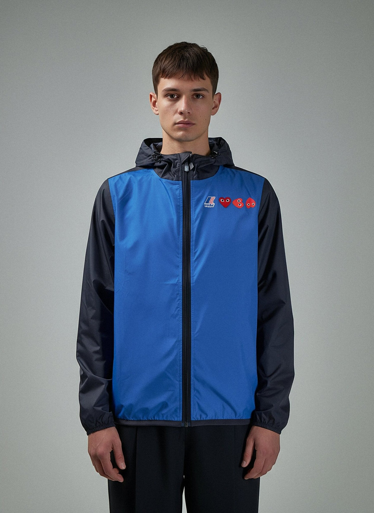 Styling shot of Comme des Garçons PLAY x K-Way raincoat for urban wear