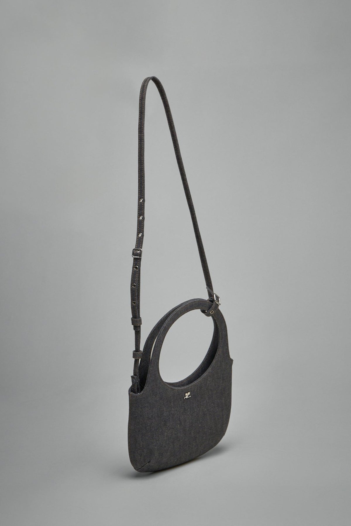 Close-up view of Courrèges Bag Holy Denim showing embossed logo and premium cotton construction