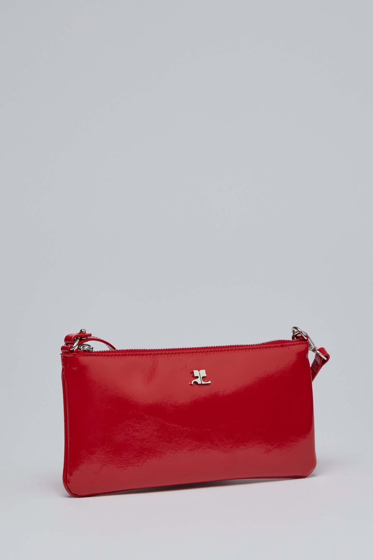 Close-up view of Courrèges red patent leather pouch zipper closure
