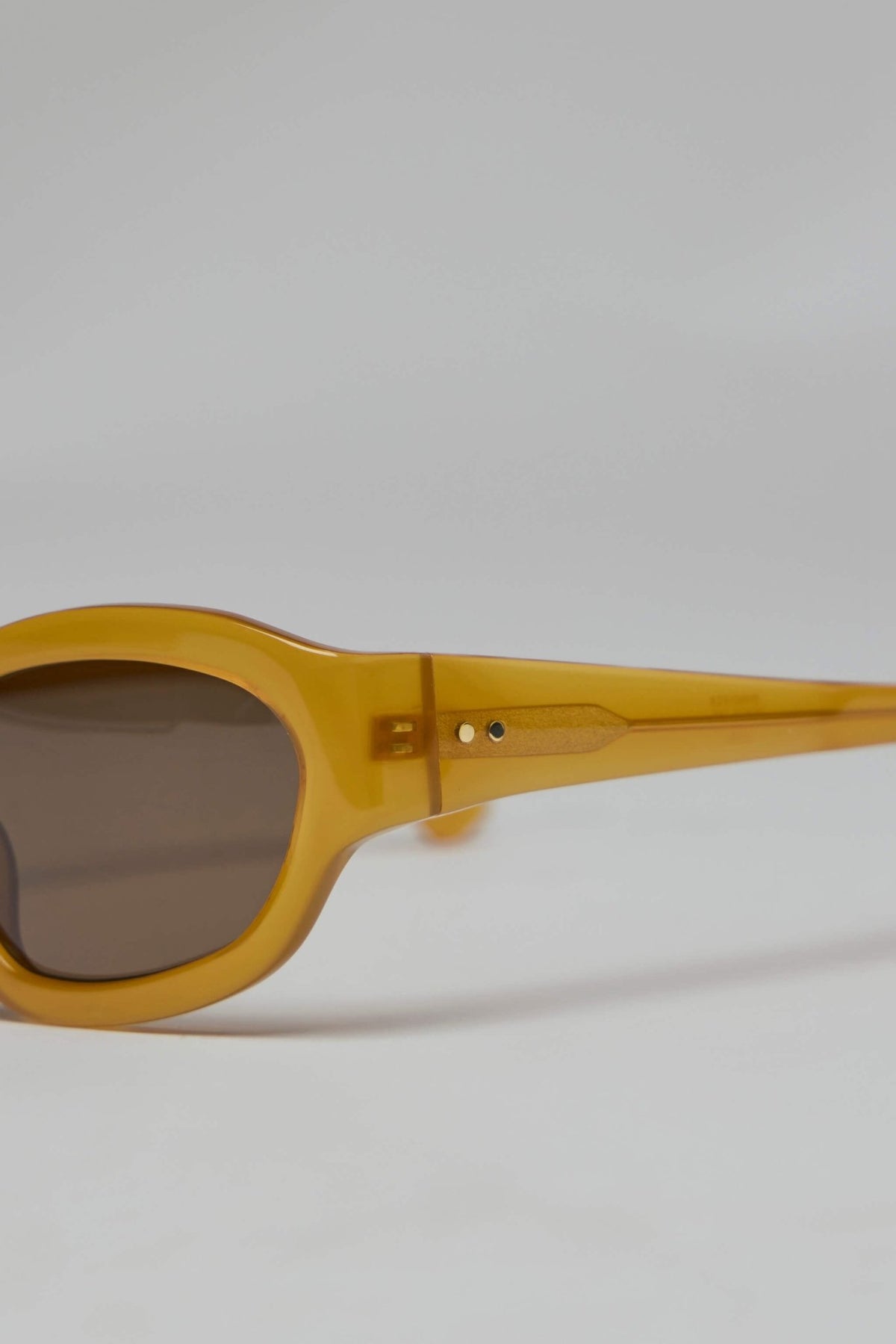 Front view of rounded yellow sunglasses with dark lenses