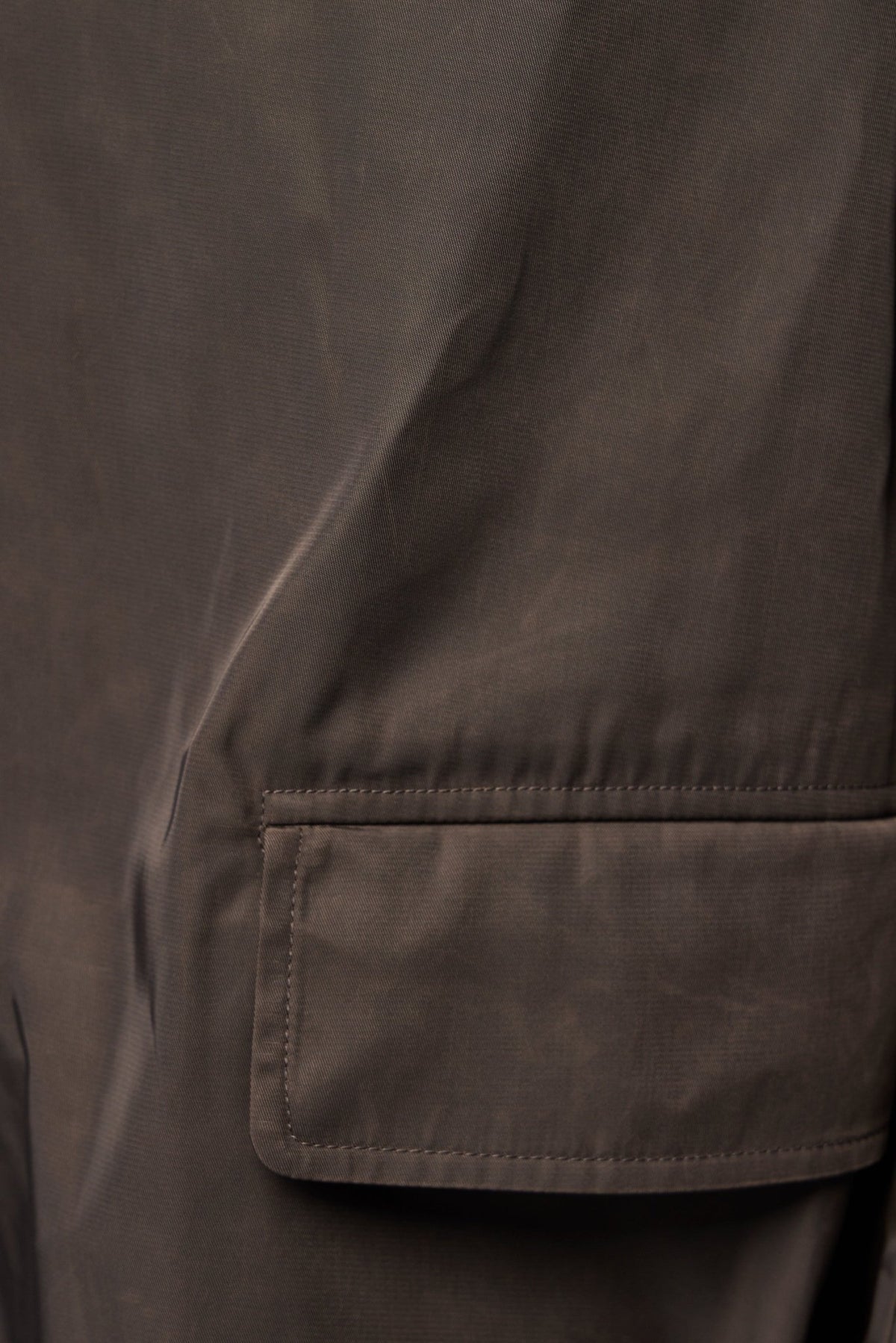 Detail shot of front pockets and button closure on wool coat